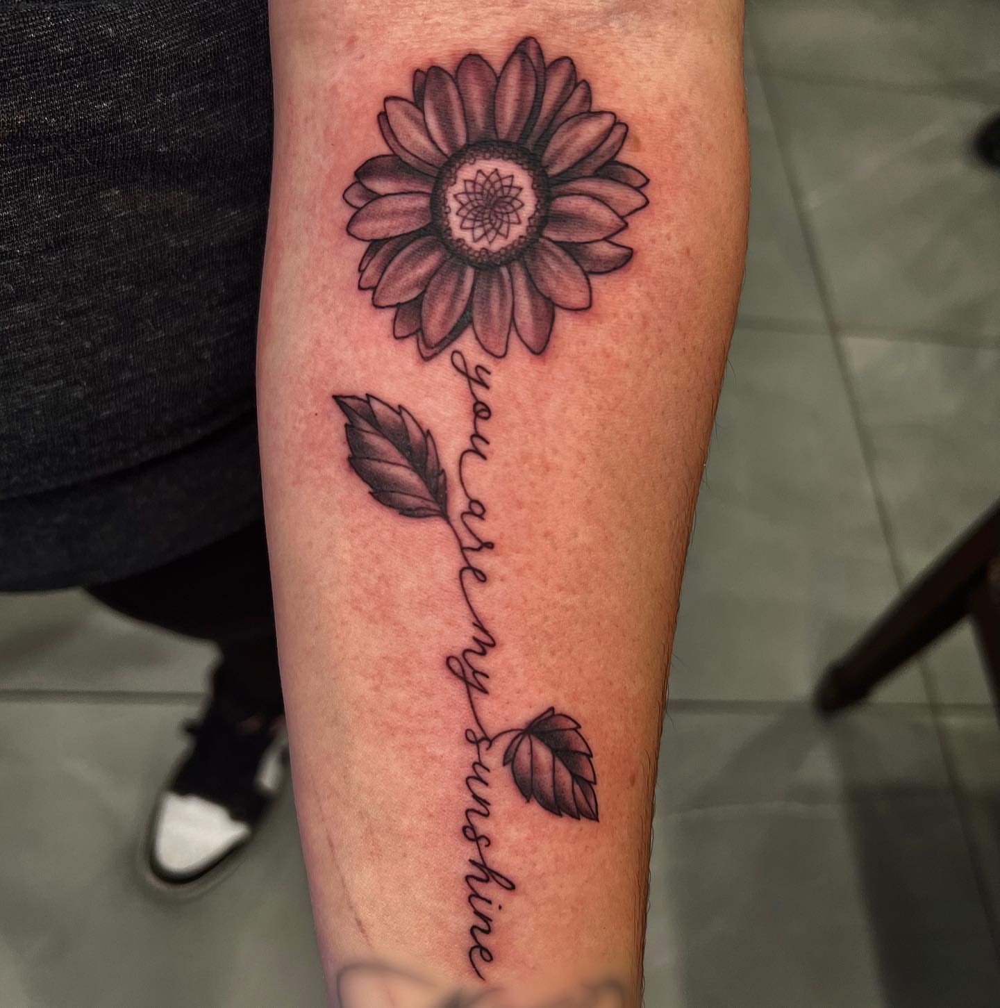 Sunflower black and grey tattoo on the forearm by Nikki Malfitano