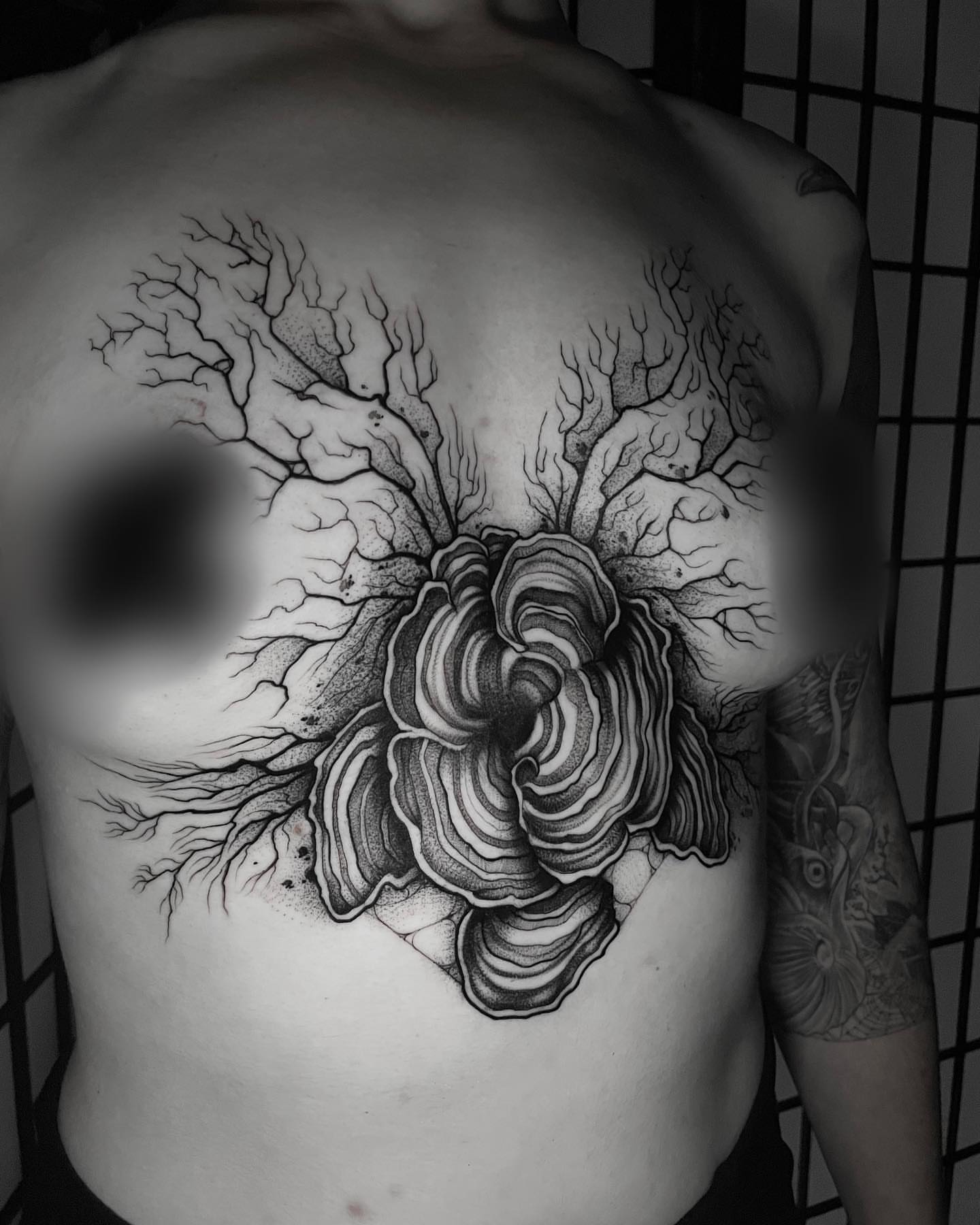 Flower with roots dotwork tattoo on the chest by Sofia Rose