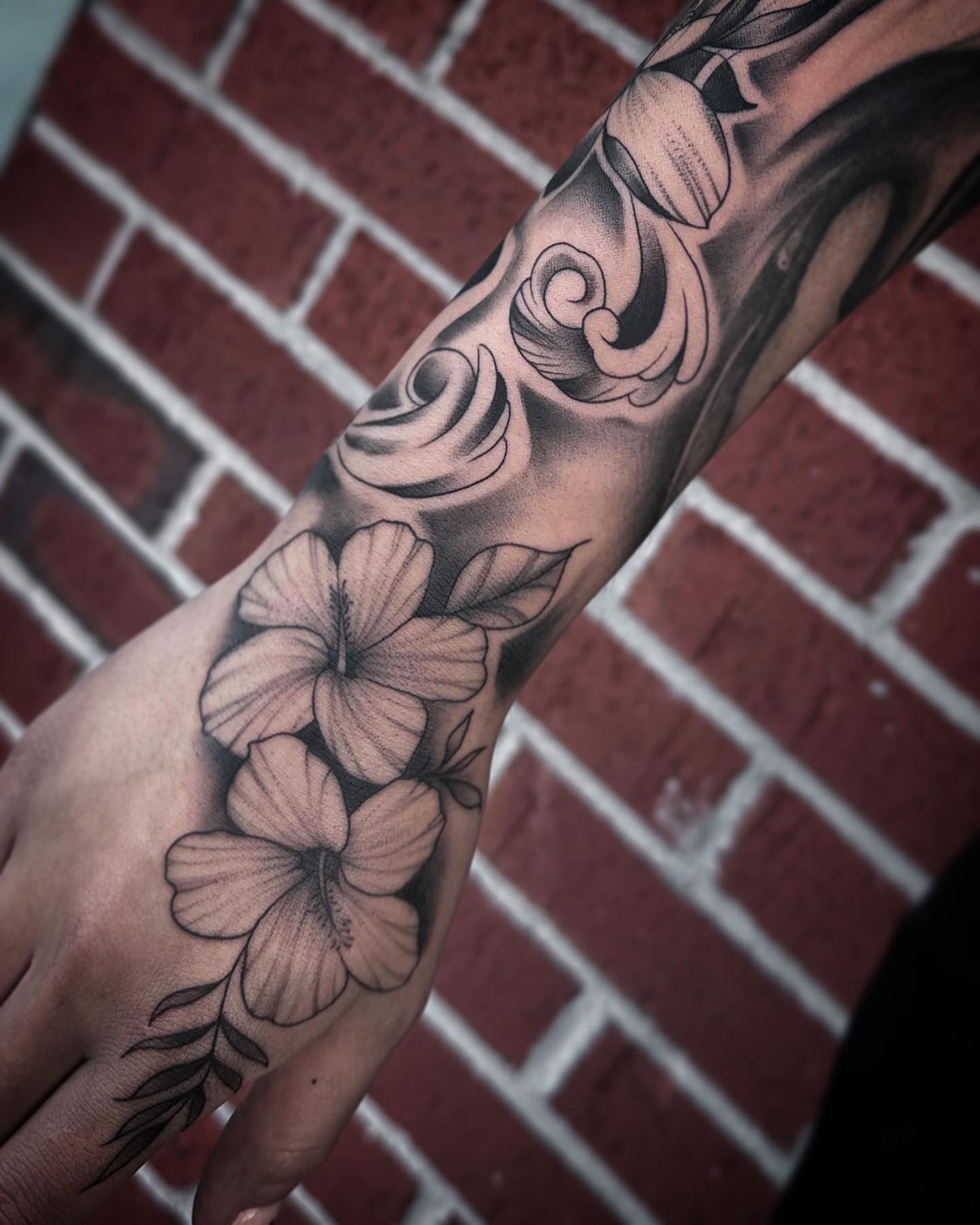 Hibiscus flowers black and grey tattoo on the forearm by Rachel Martinez