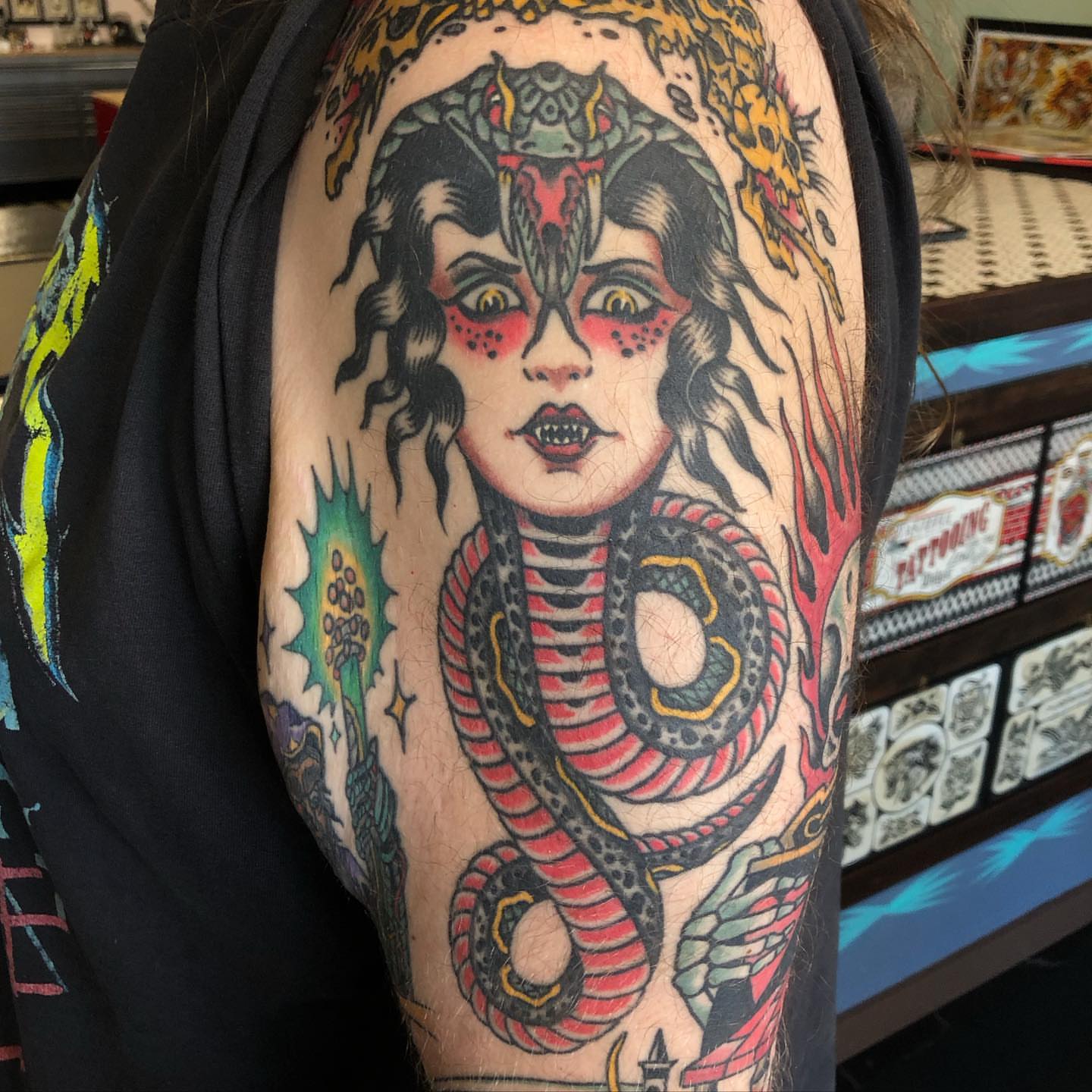 Woman with snake American traditional tattoo on the upper arm by Sean McMahon