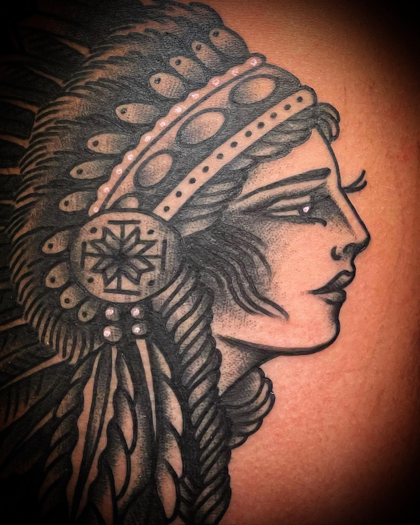 Indian headdress American traditional tattoo on the shoulder by Alex Muniz