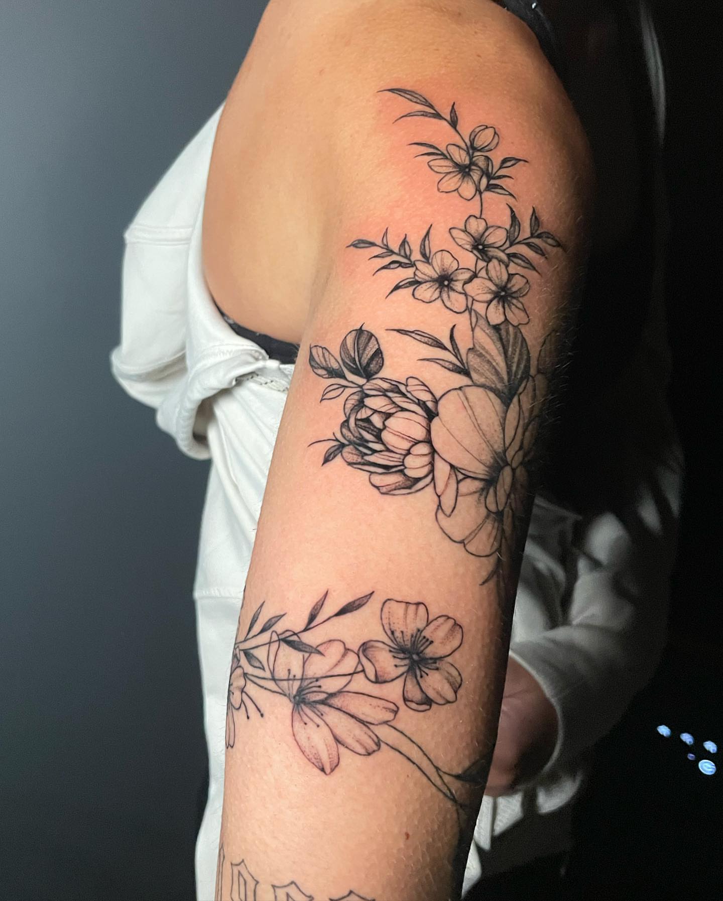 Floral arrangement black and grey tattoo on the forearm by Nate Masi