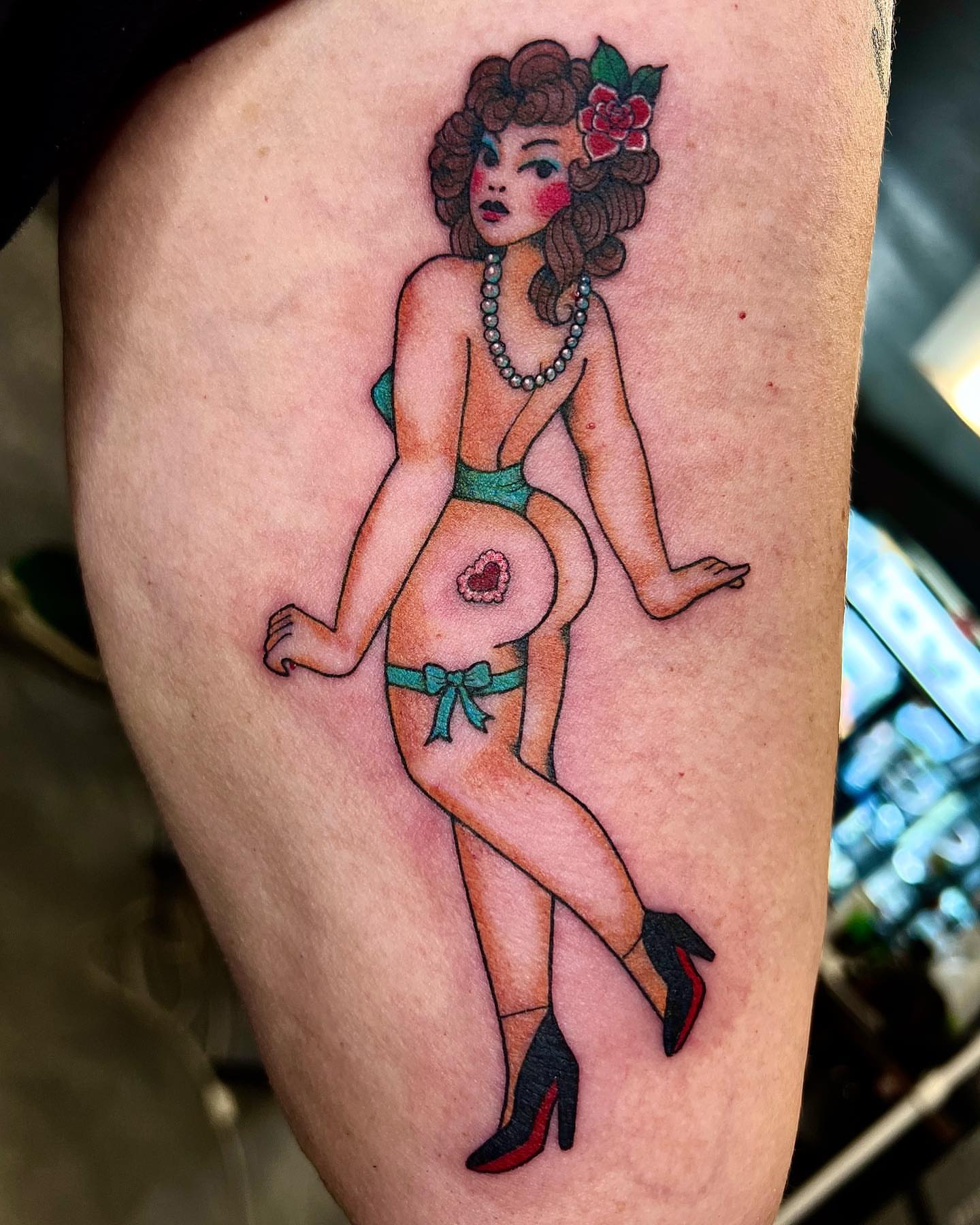 Pin-up girl American traditional tattoo on the thigh by Pam Sanders