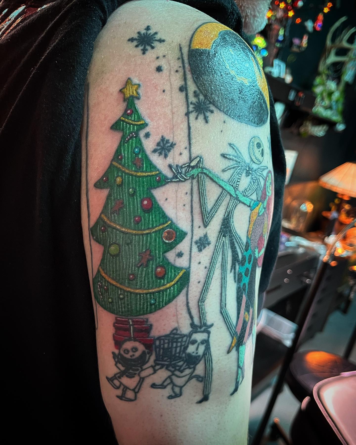 Christmas tree and jack skellington dotwork tattoo on the upper arm by alexandra