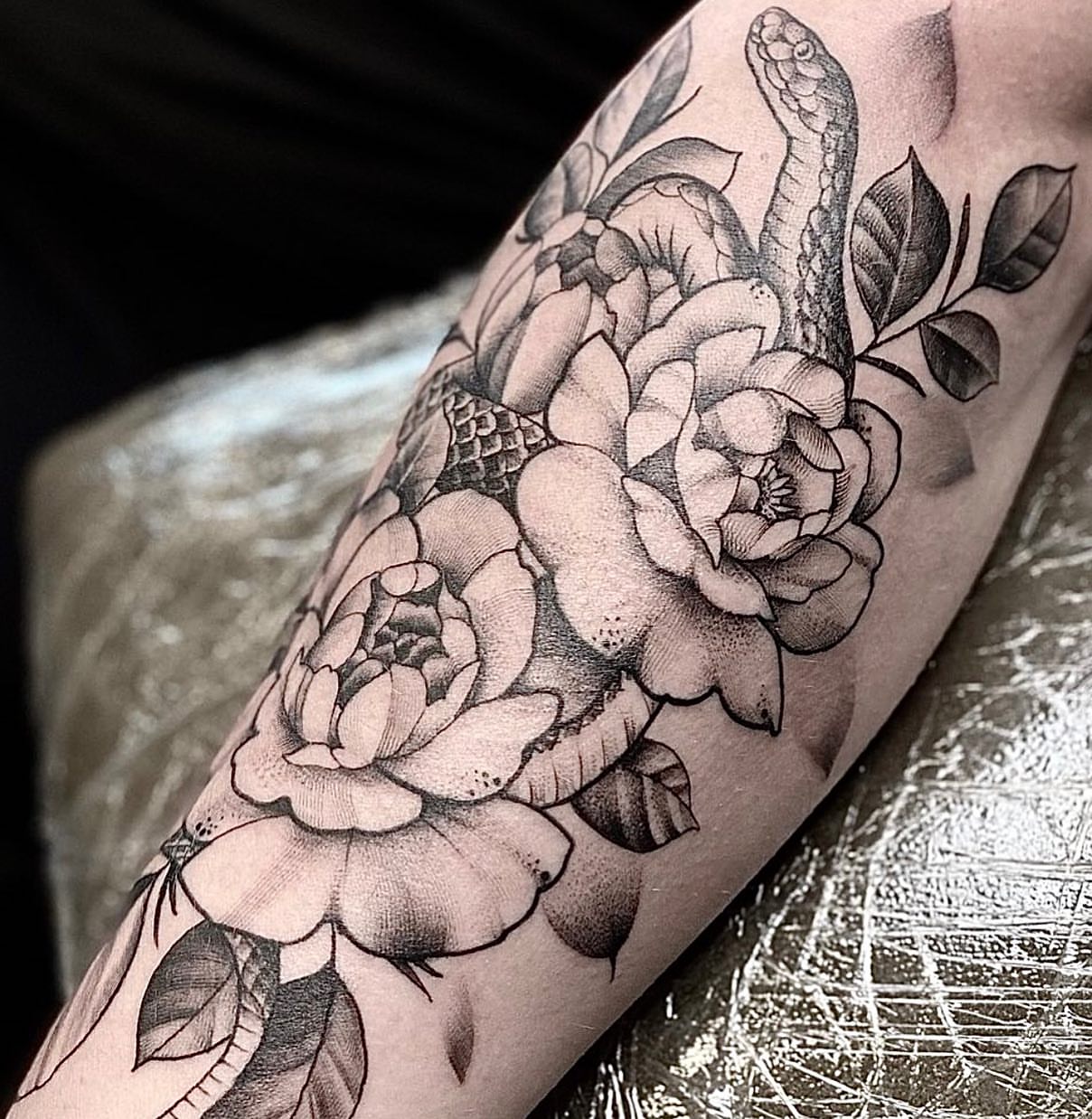 Snake and peony realism tattoo on the forearm by Matthew Clanin