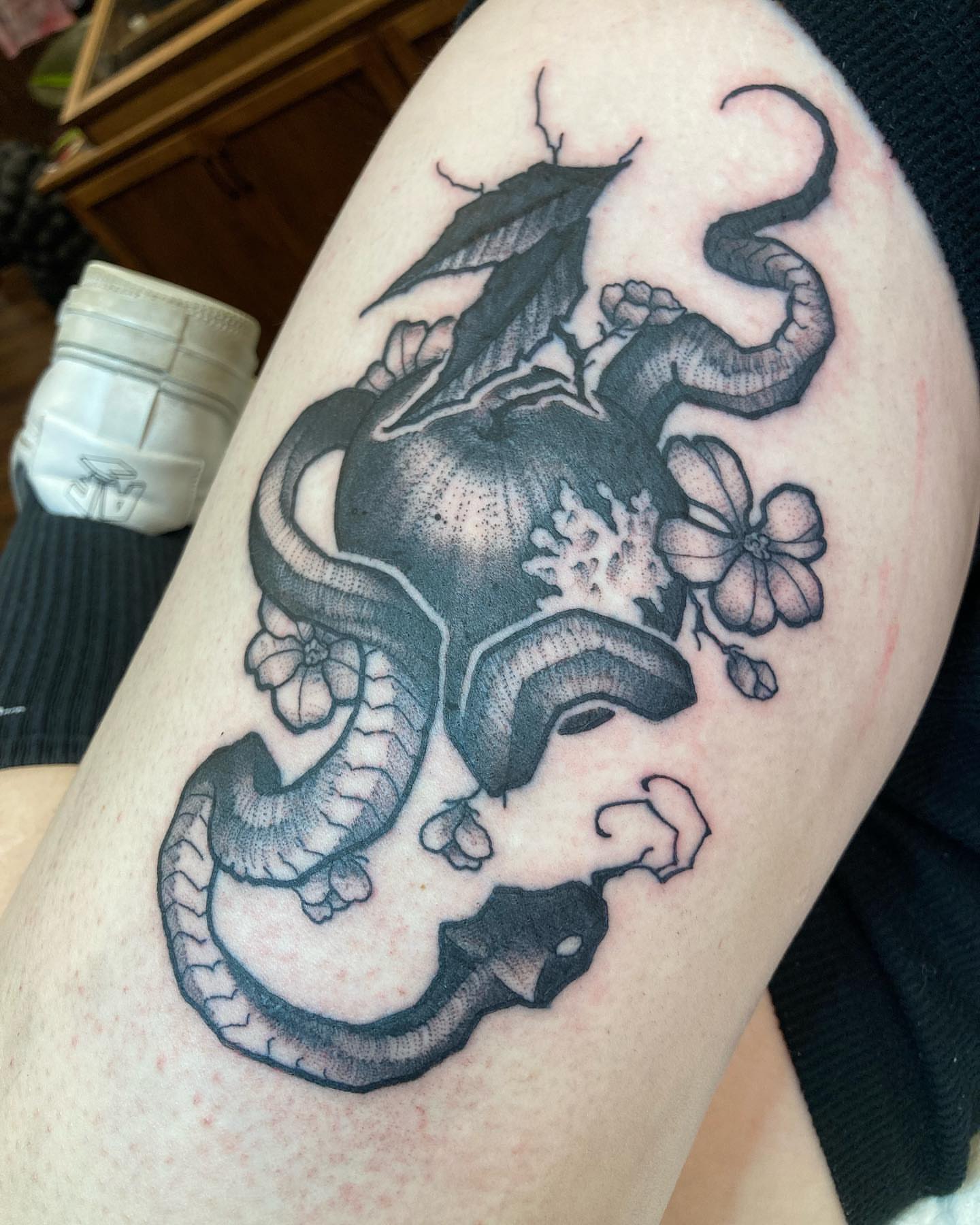 Dragon and flowers realism tattoo on the thigh by Griffin Benson