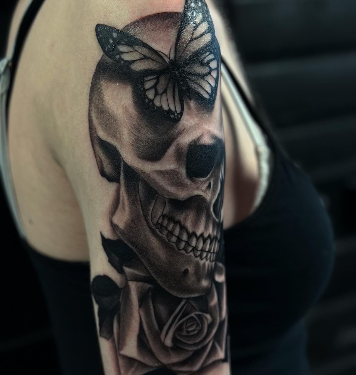 Skull with butterfly and rose realism tattoo on the shoulder by audi