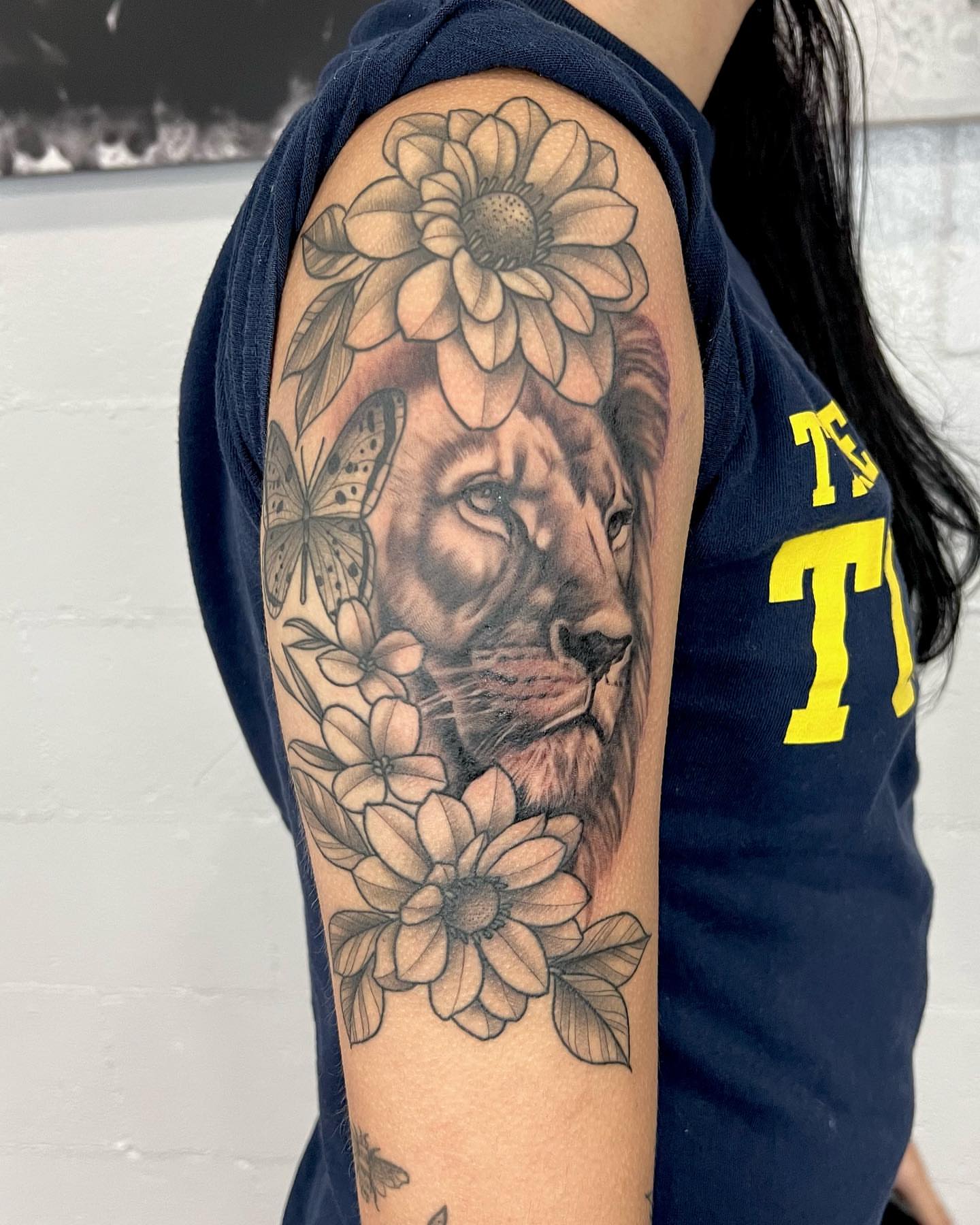 Lion with flowers realism tattoo on the forearm by Drew Foster, Toledo, Ohio