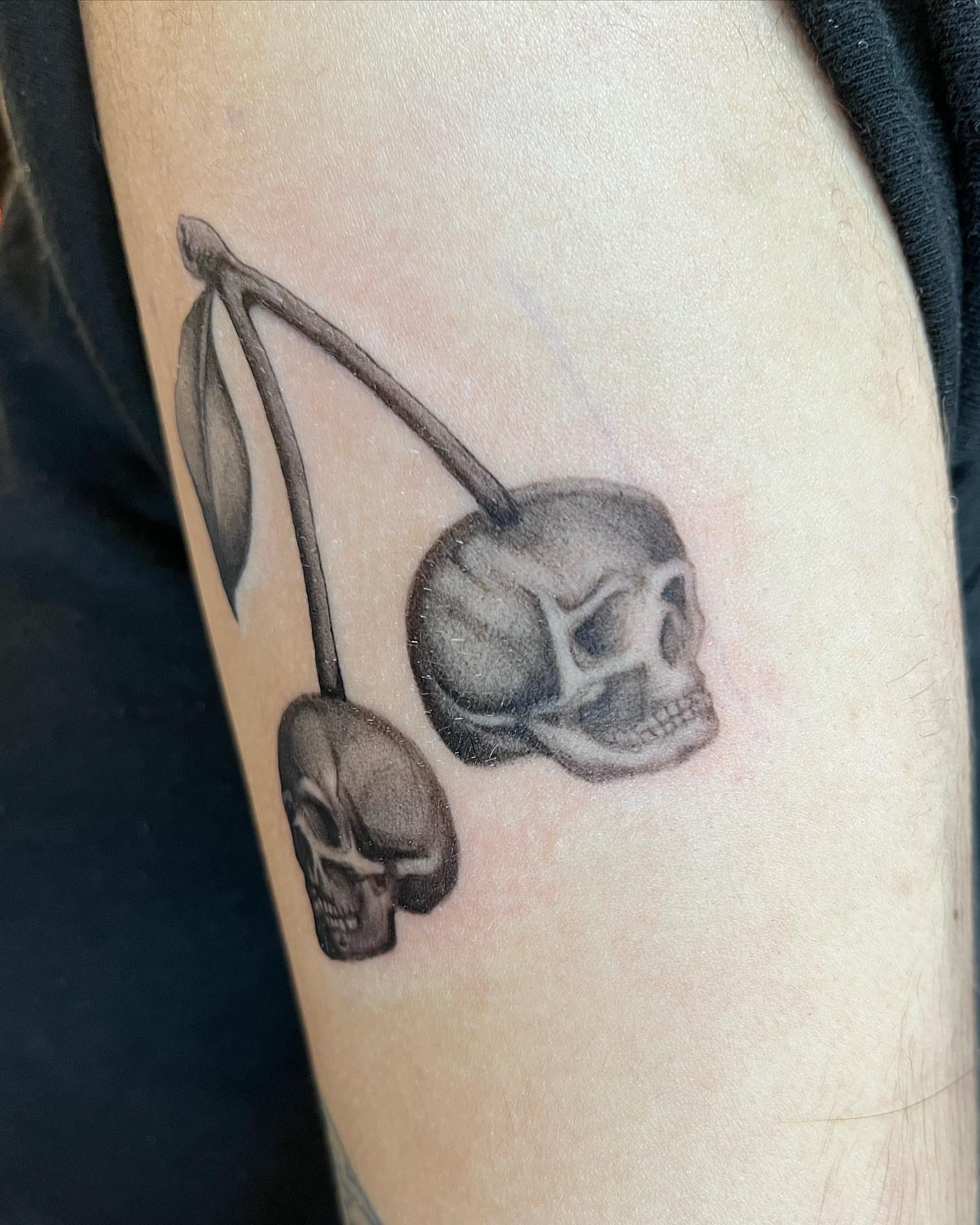 Cherry and skull realism tattoo on the forearm by Anthony “Jiinky” Quintanilla 🧸☁️