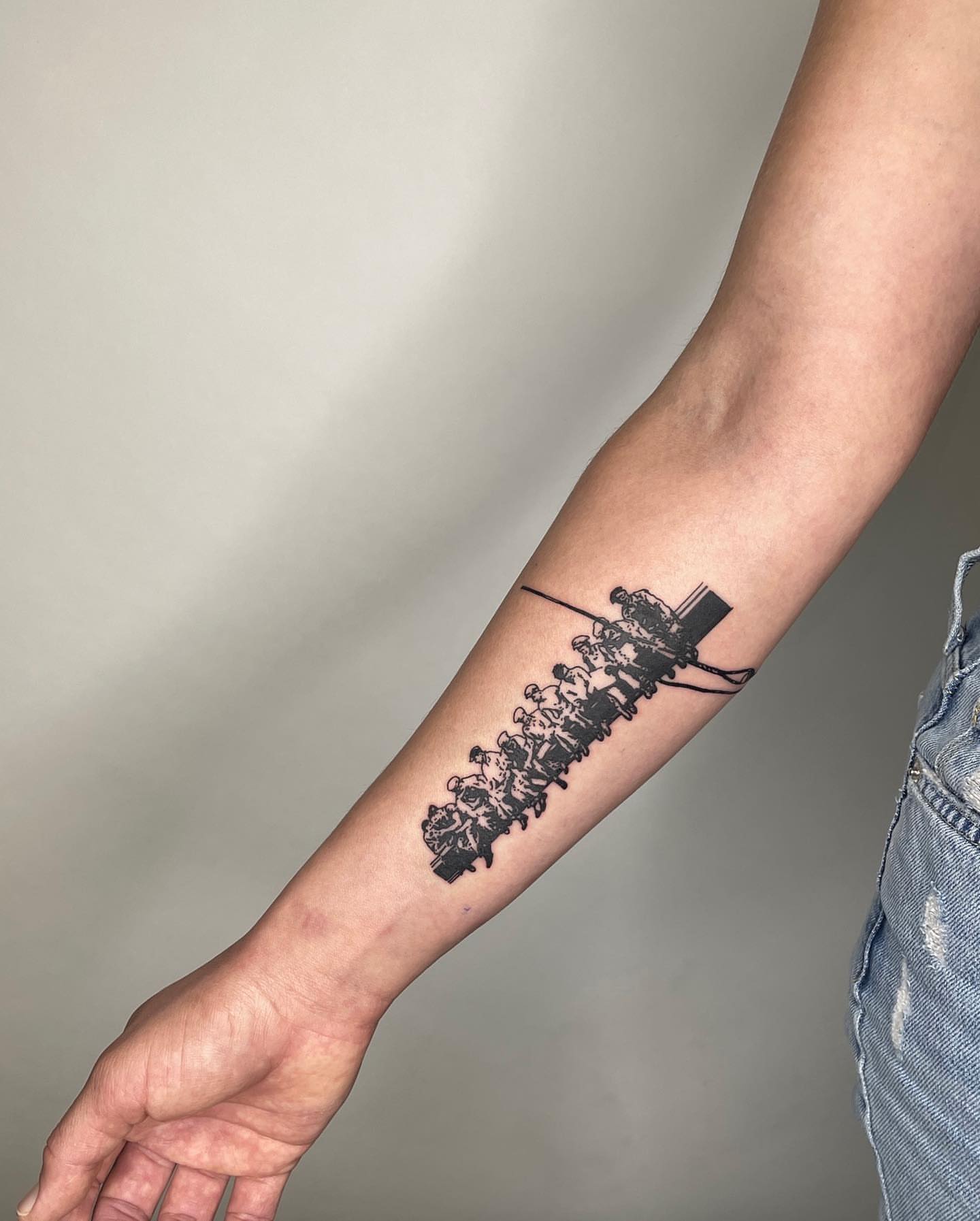 Crowd on bridge black and grey tattoo on the forearm by utility pole