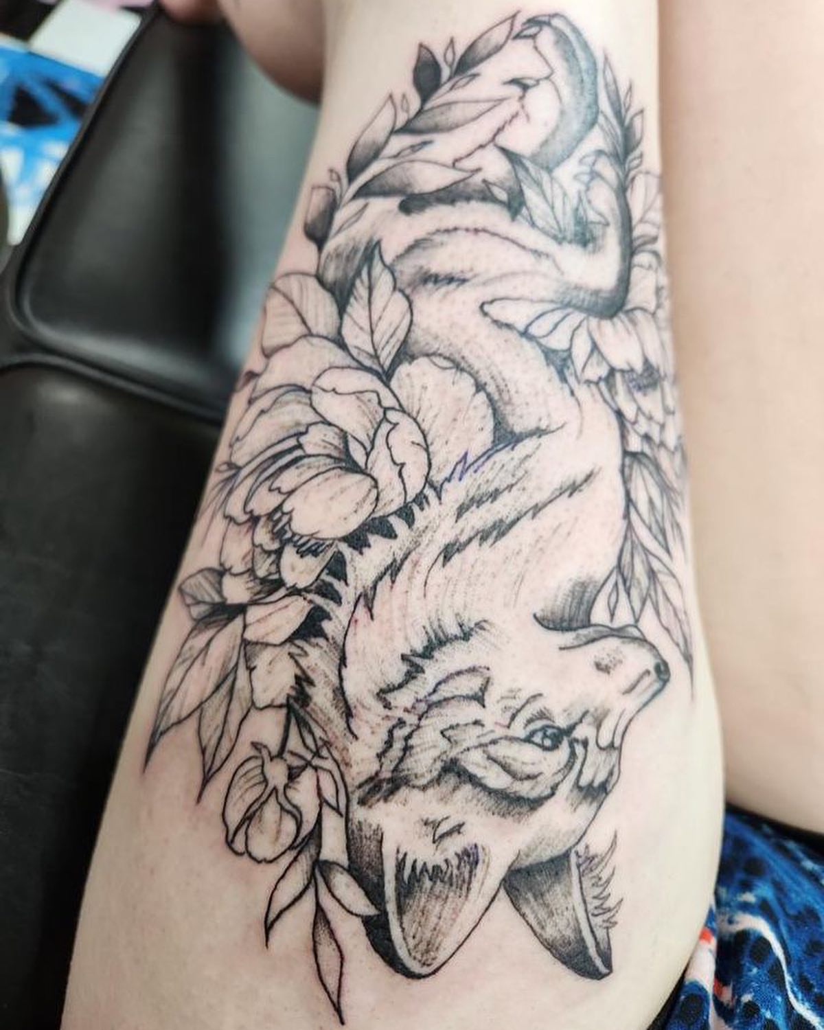 Dog and floral realism tattoo on the forearm by Dre Ortiz