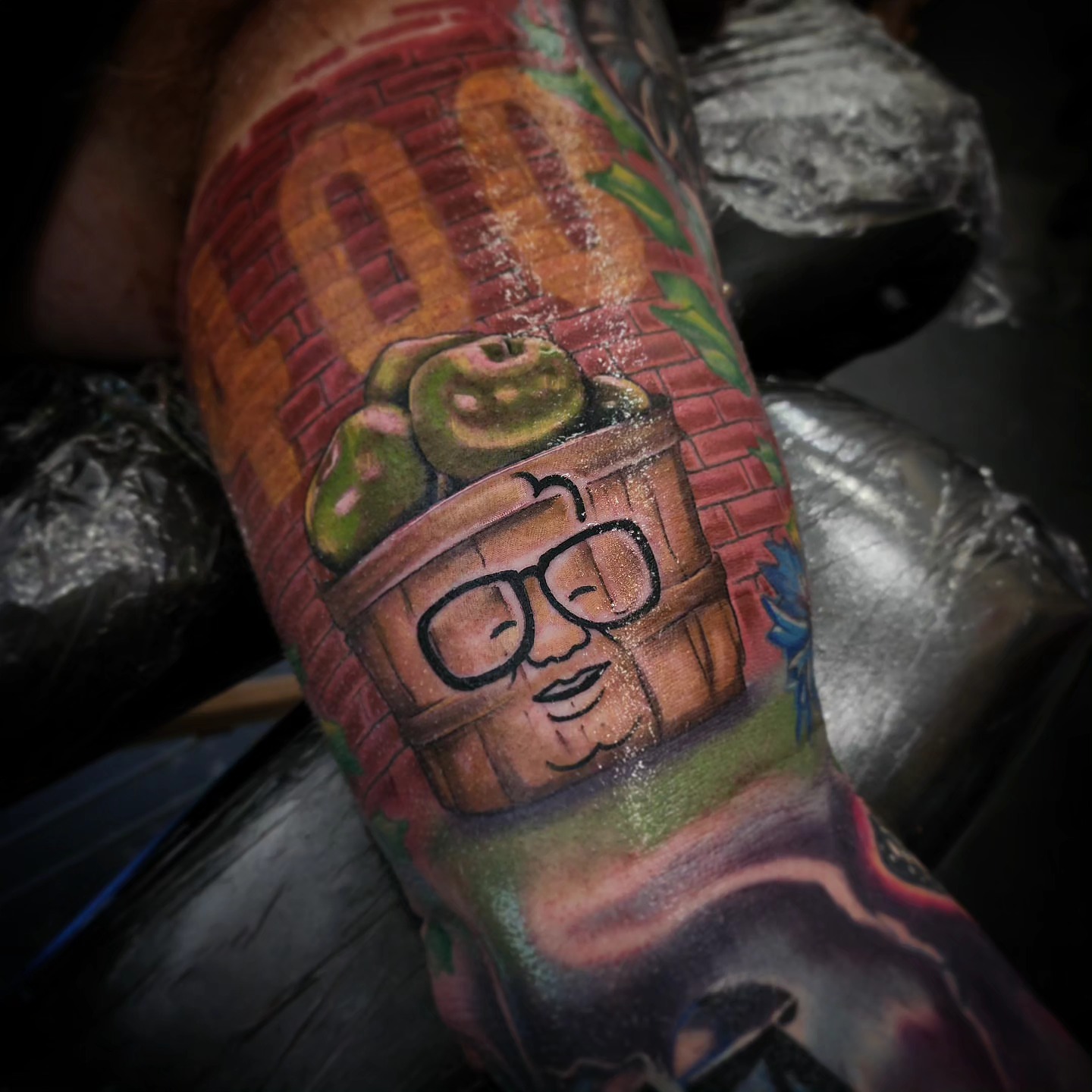 Trash can with apples realism tattoo on the forearm by Drew Siciliano, Glendale, Arizona