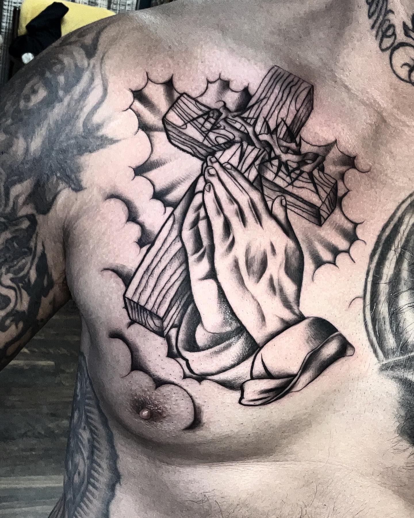 Praying hands with cross realism tattoo on the chest by Las Vegas Tattoo Artist