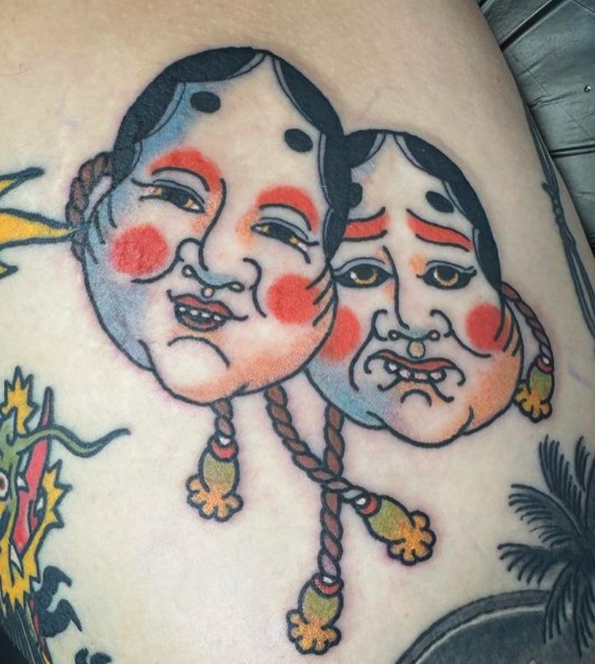 Two faces American traditional tattoo on the thigh by Blake Brand