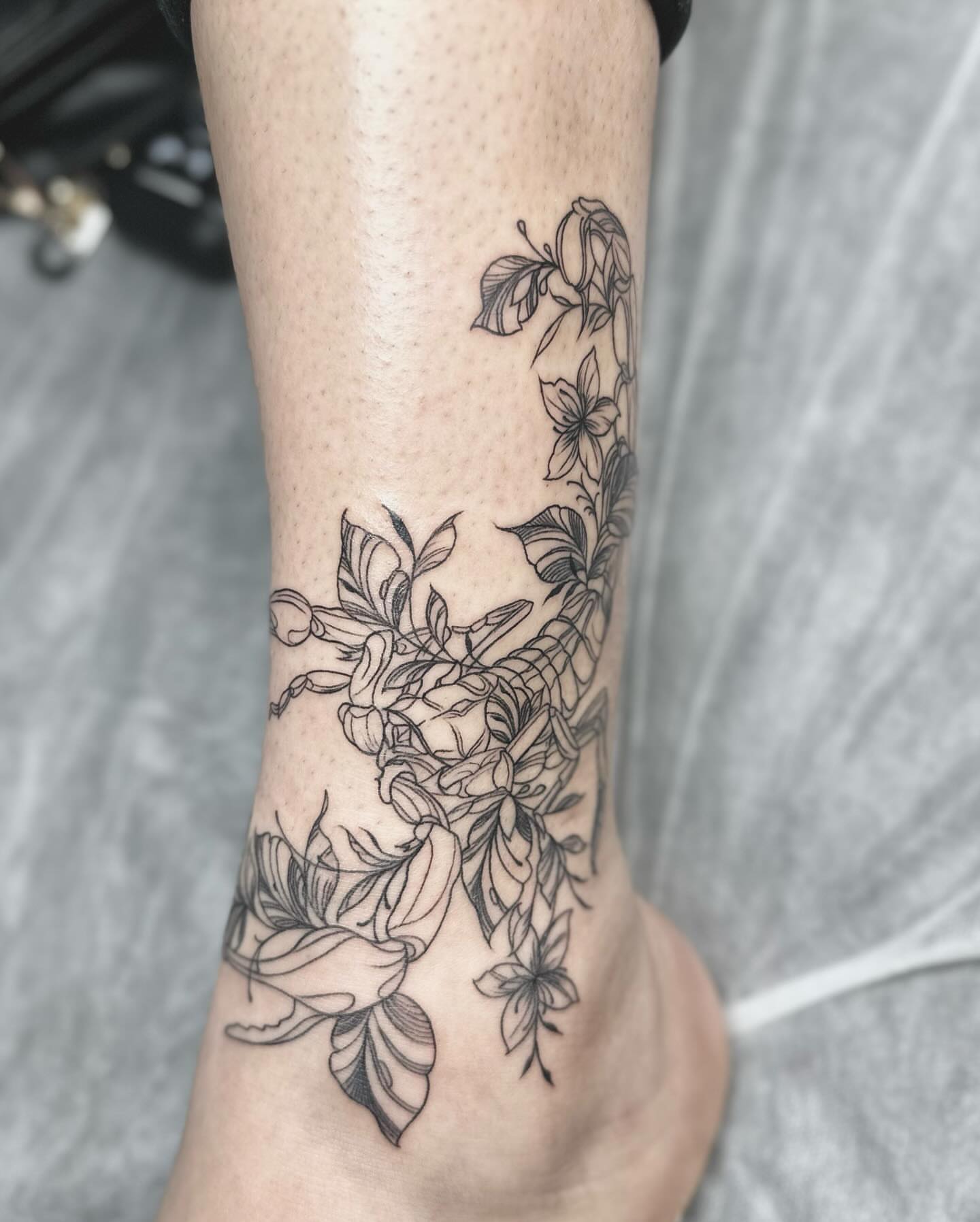 Floral arrangement black and grey tattoo on the calf by DJ 👨🏾‍🎨