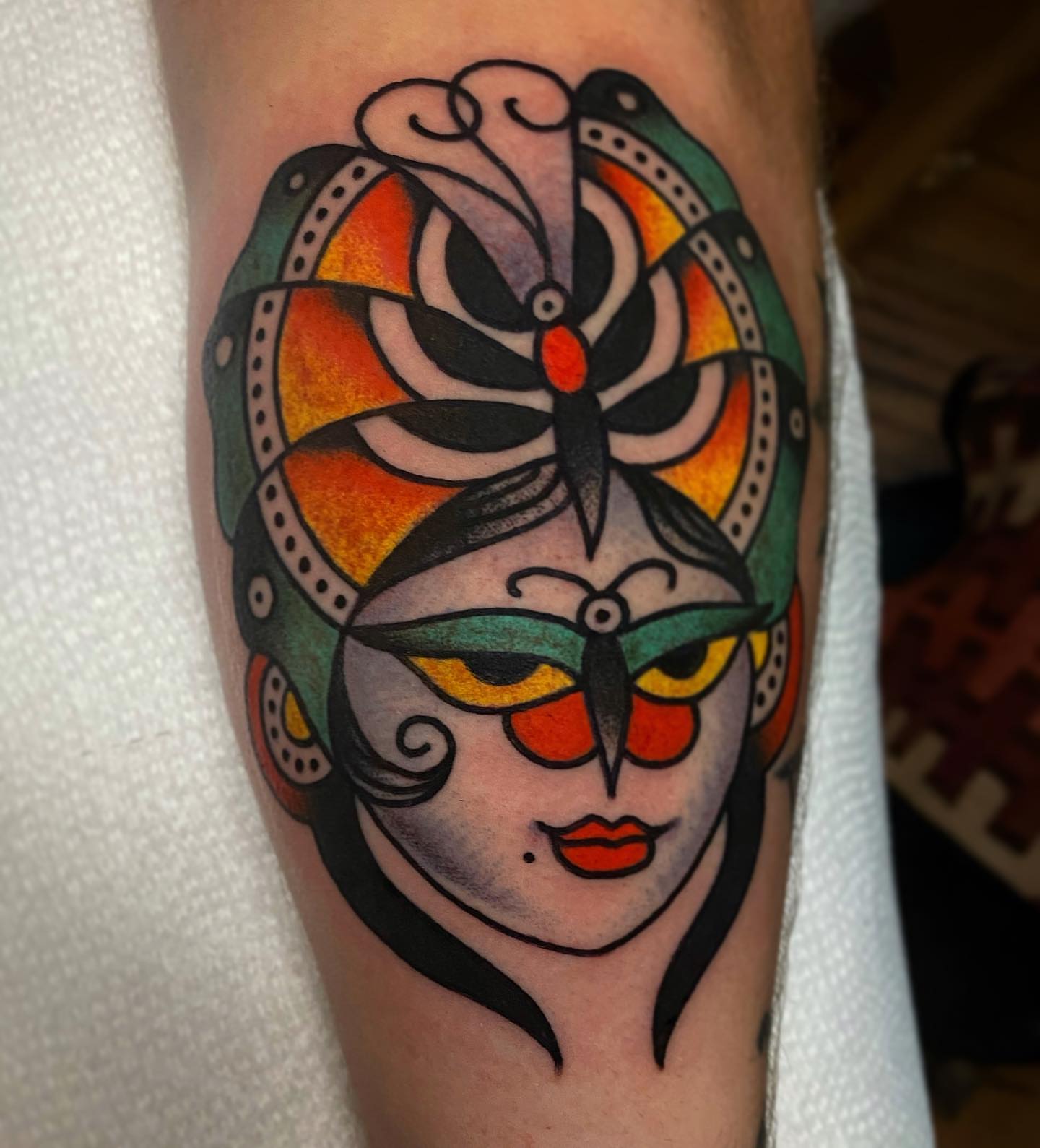 Mask American traditional tattoo on the forearm by Britney Goodman