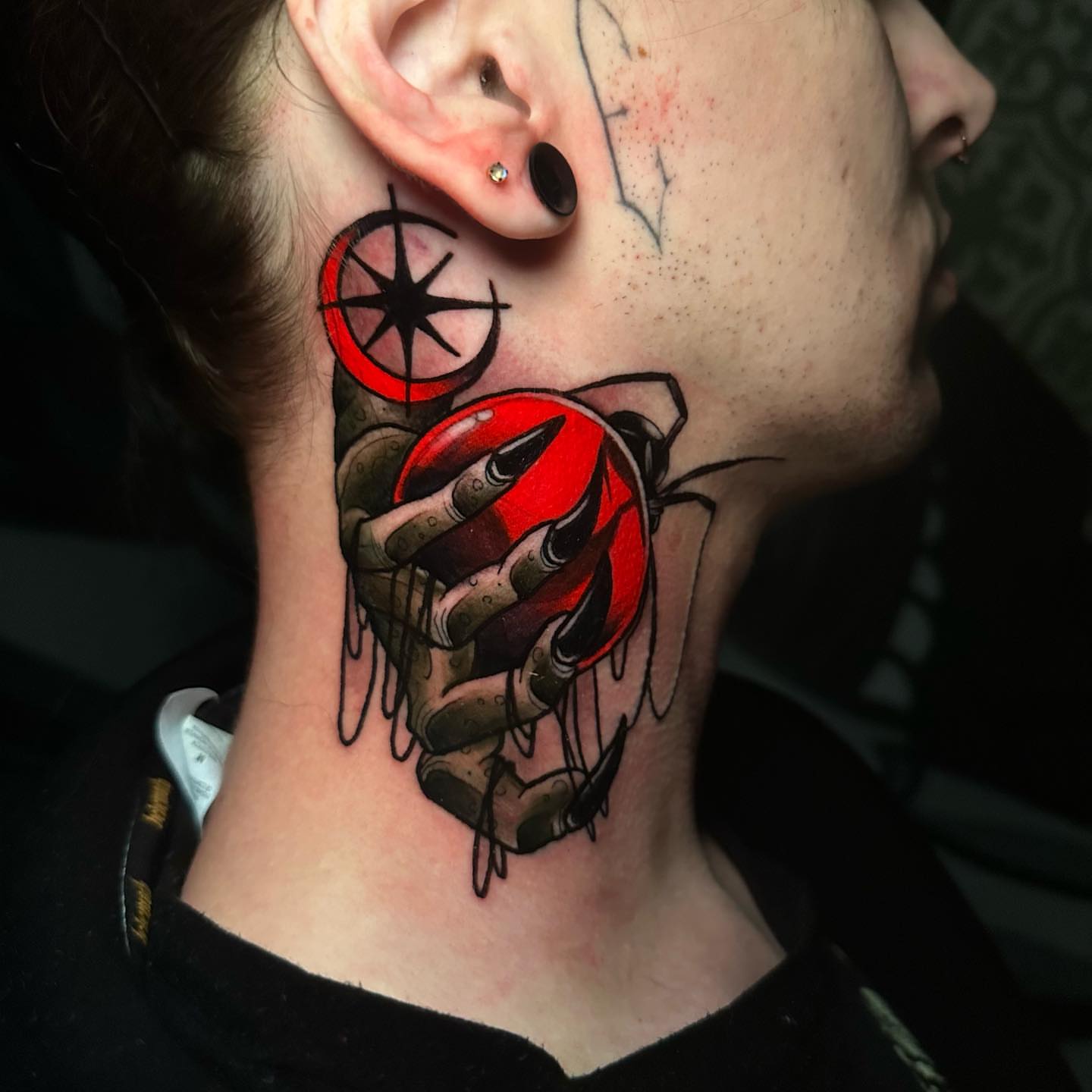 Hand holding beetle realism tattoo on the neck by gillian marie