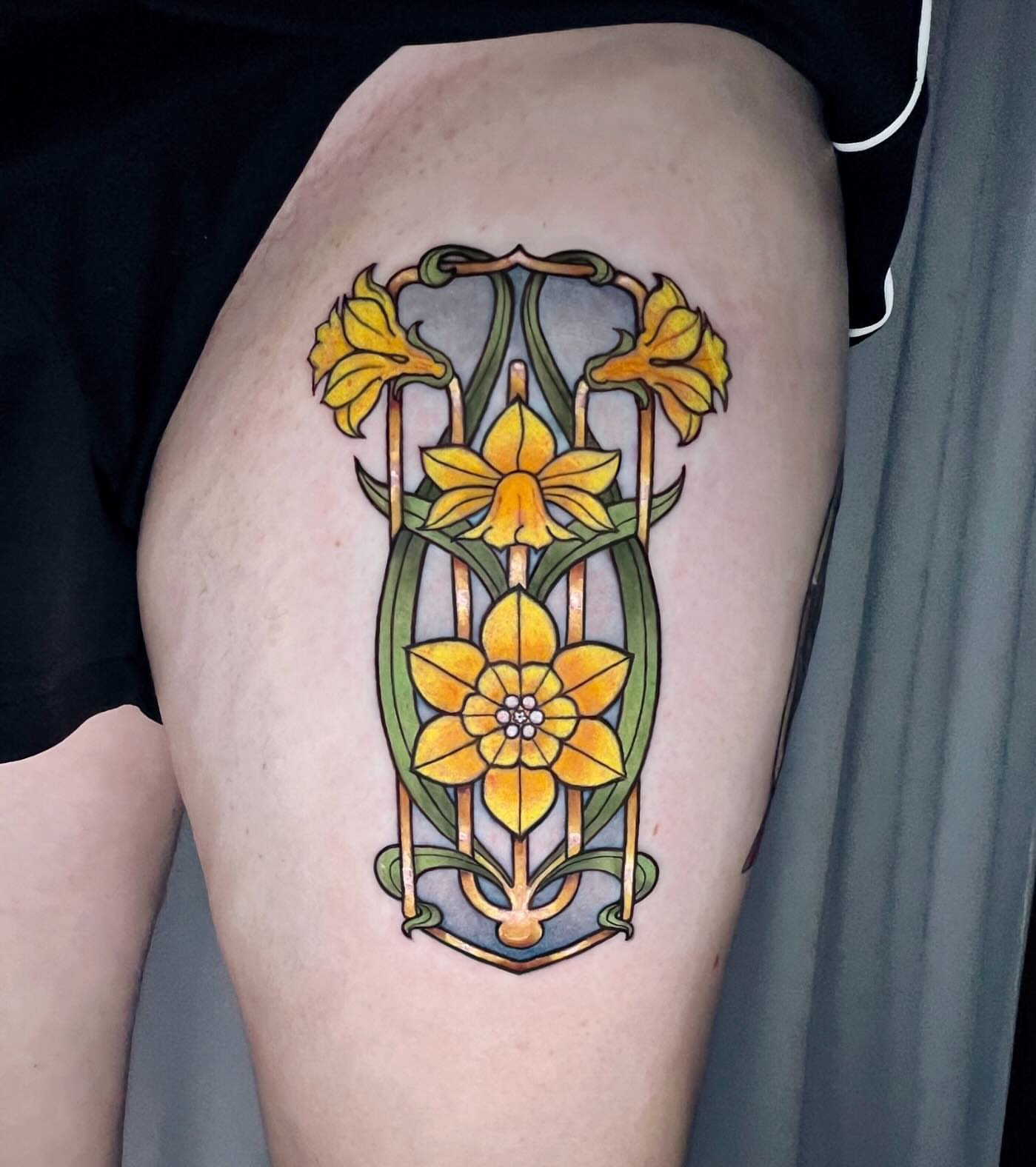 Daffodils ornamental tattoo on the thigh by Cortney Norton