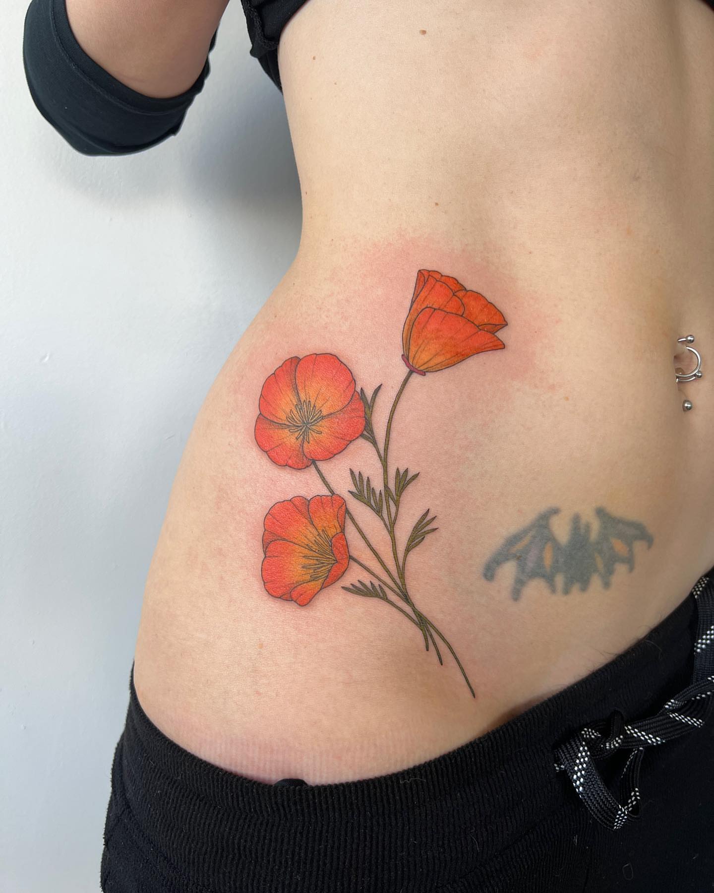 California poppies realism tattoo on the ribs by See See : botanical tattoo artist :