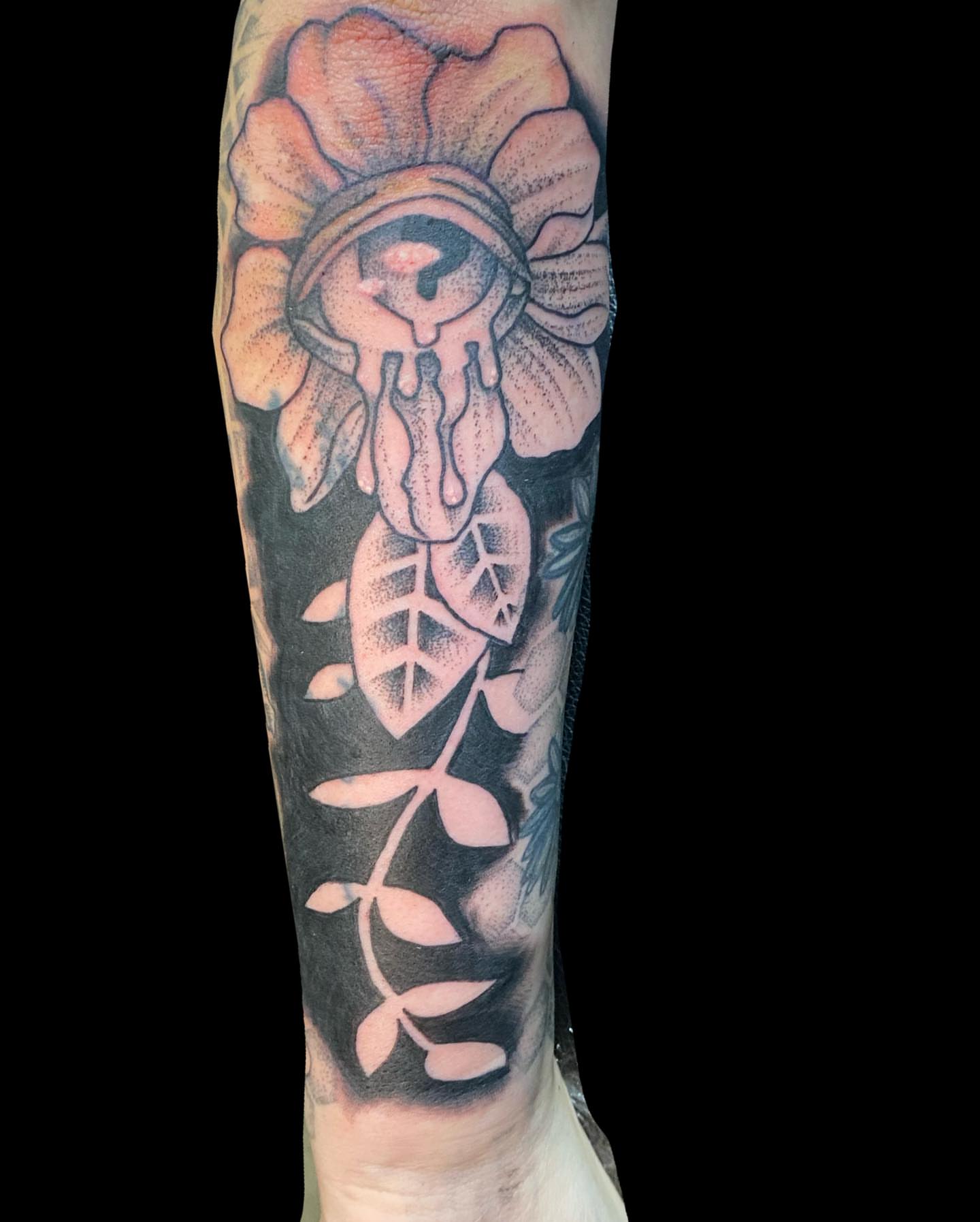 Flower with dripping eye black and grey tattoo on the forearm by Shelby Warren