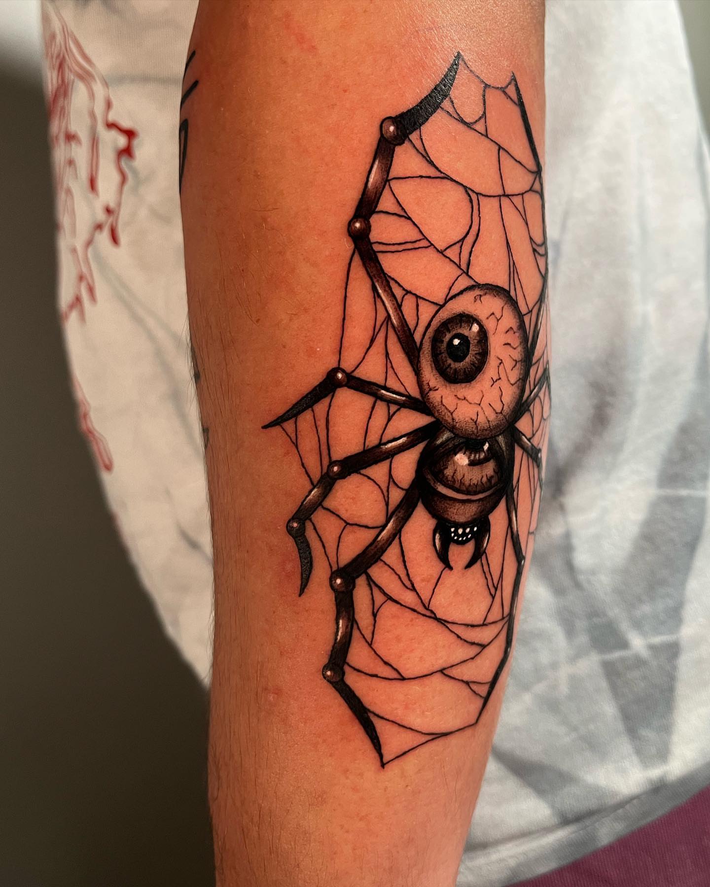 Spider and eye geometric tattoo on the forearm by Anthony “Jiinky” Quintanilla 🧸☁️