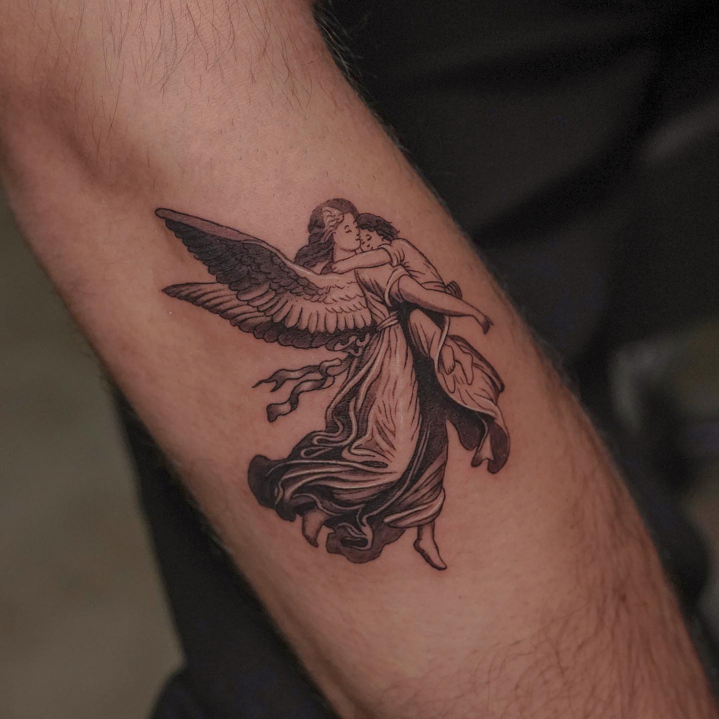 Angel and child black and grey tattoo on the forearm by eddie chavez
