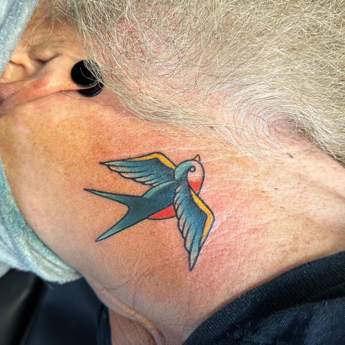 Swallow American traditional tattoo on the neck by Gabby Tolley🌛