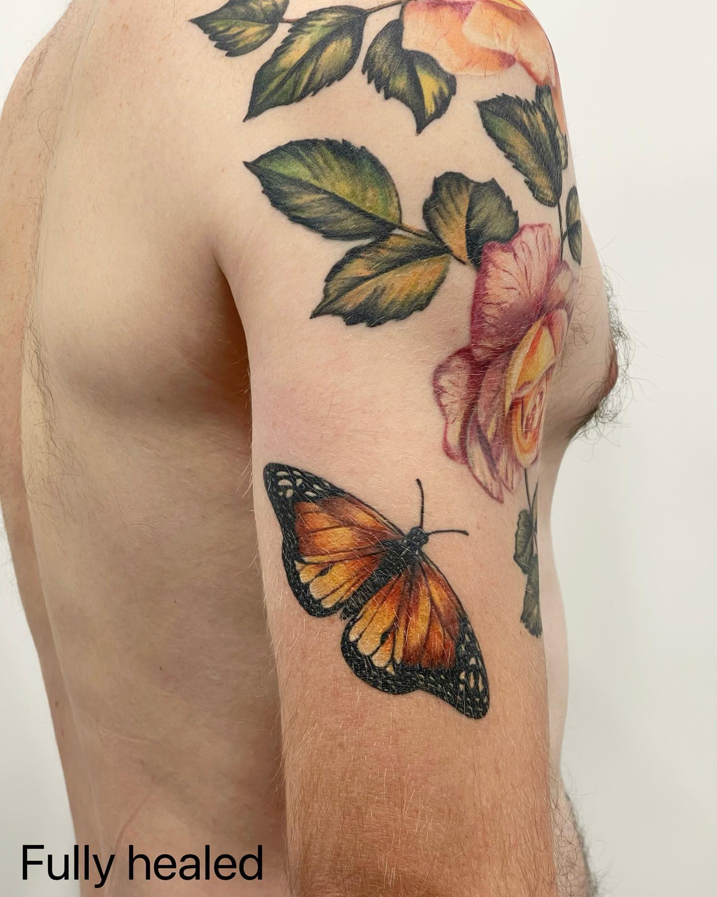 Butterfly and flowers realism tattoo on the upper arm by Seattle Tattoo Artist PingPing, Seattle, Washington