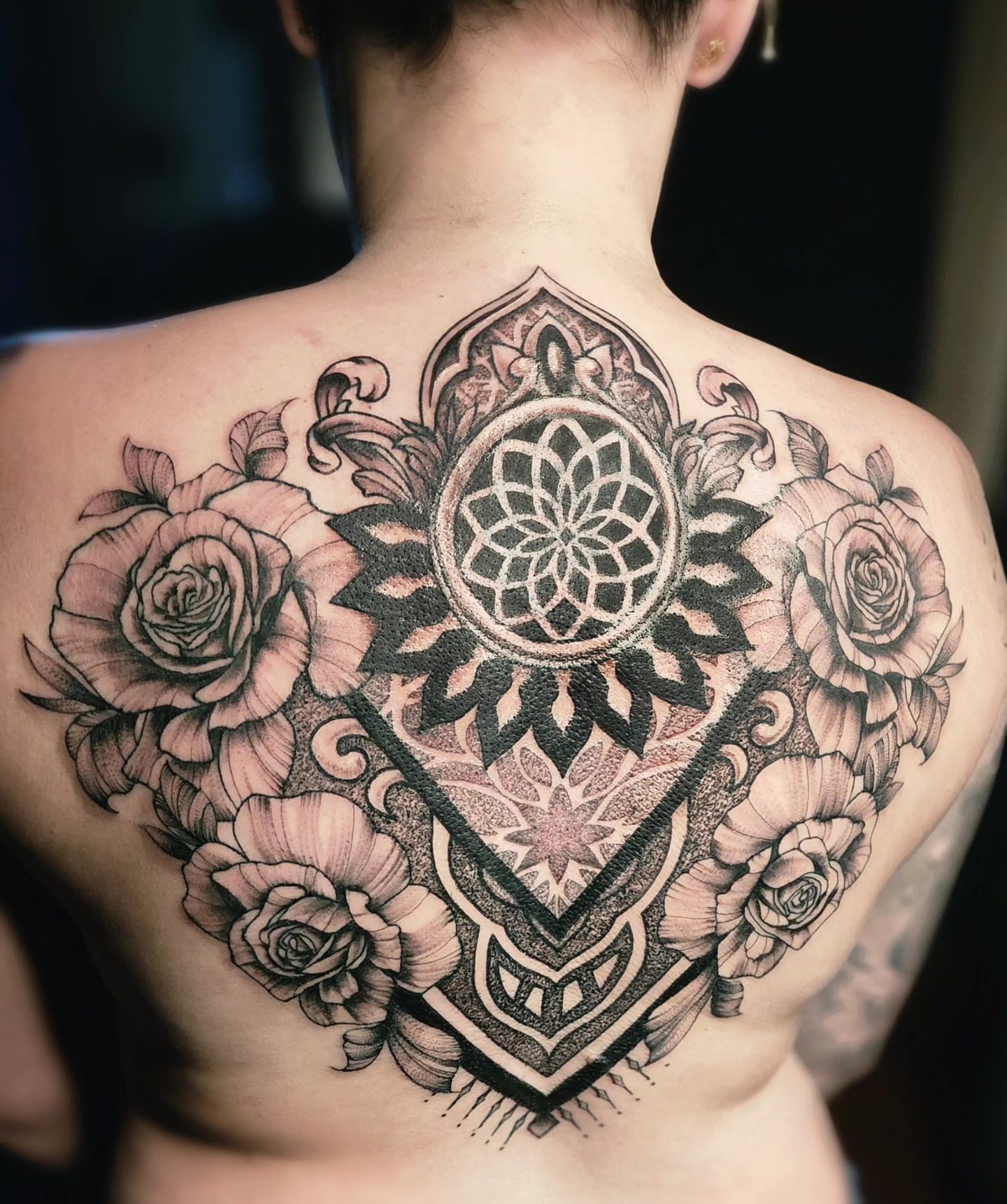 Mandala with roses geometric tattoo on the back by Neil Ohmie