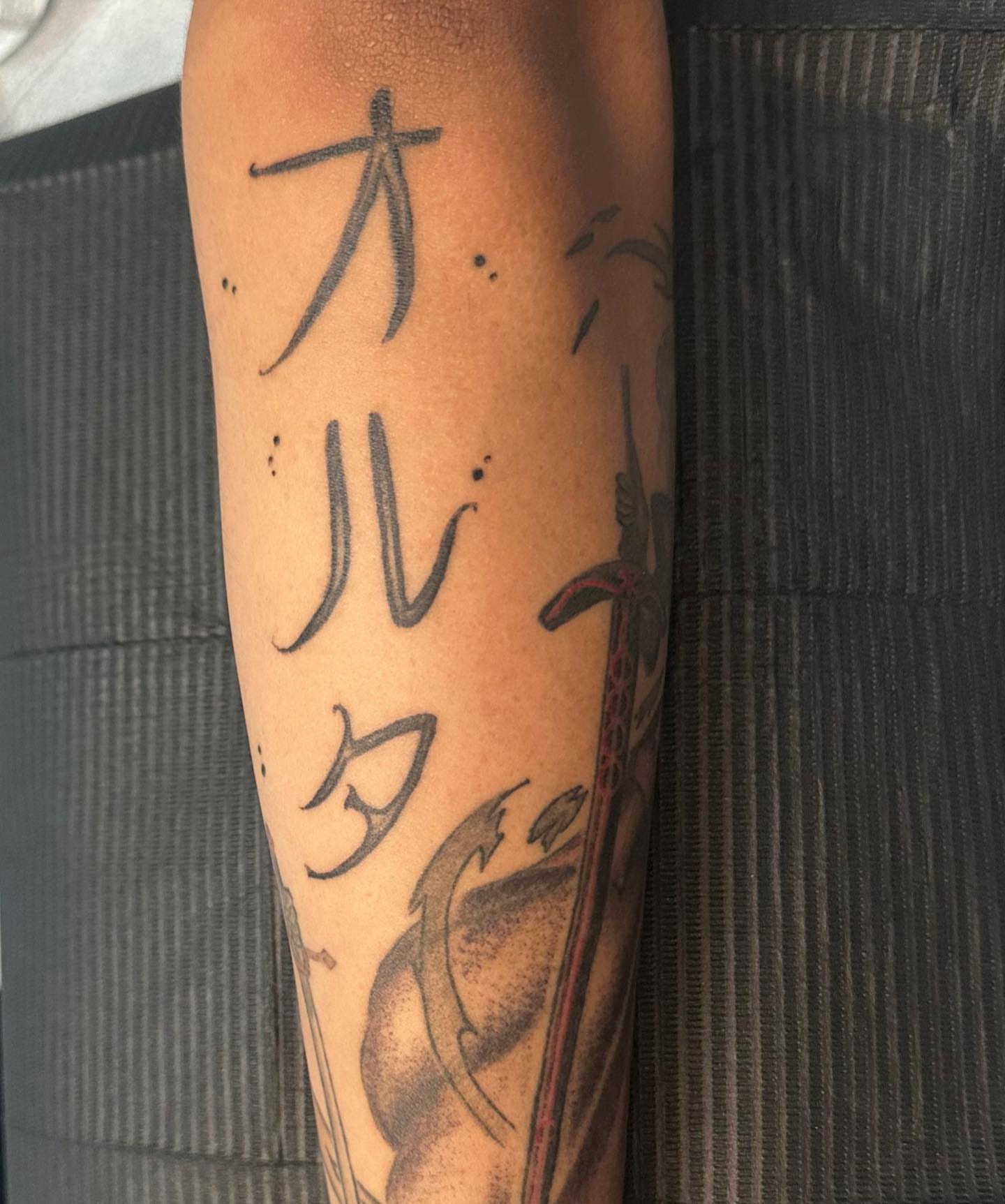 Kanji characters black and grey tattoo on the forearm by Mika