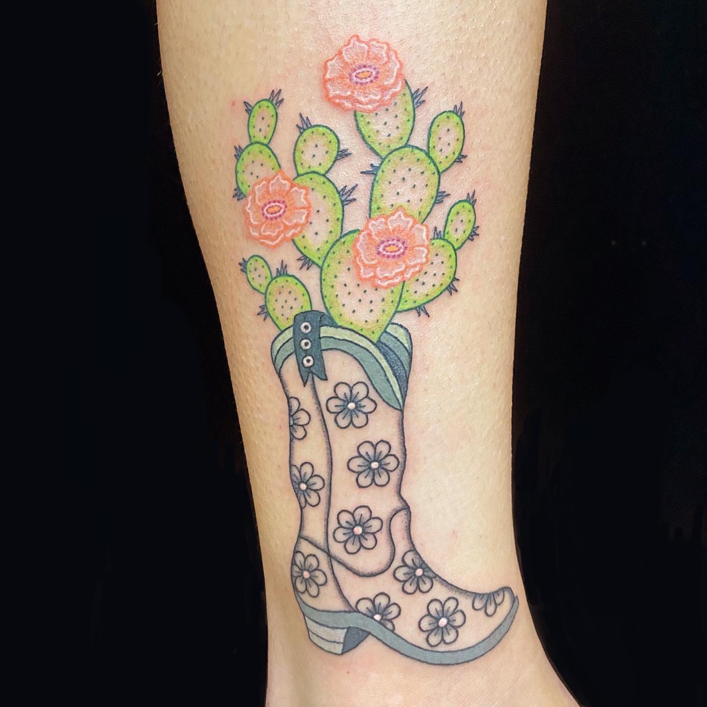 Cowboy boots and cactus flowers American traditional tattoo on the calf by Krista - Tattoo Artist