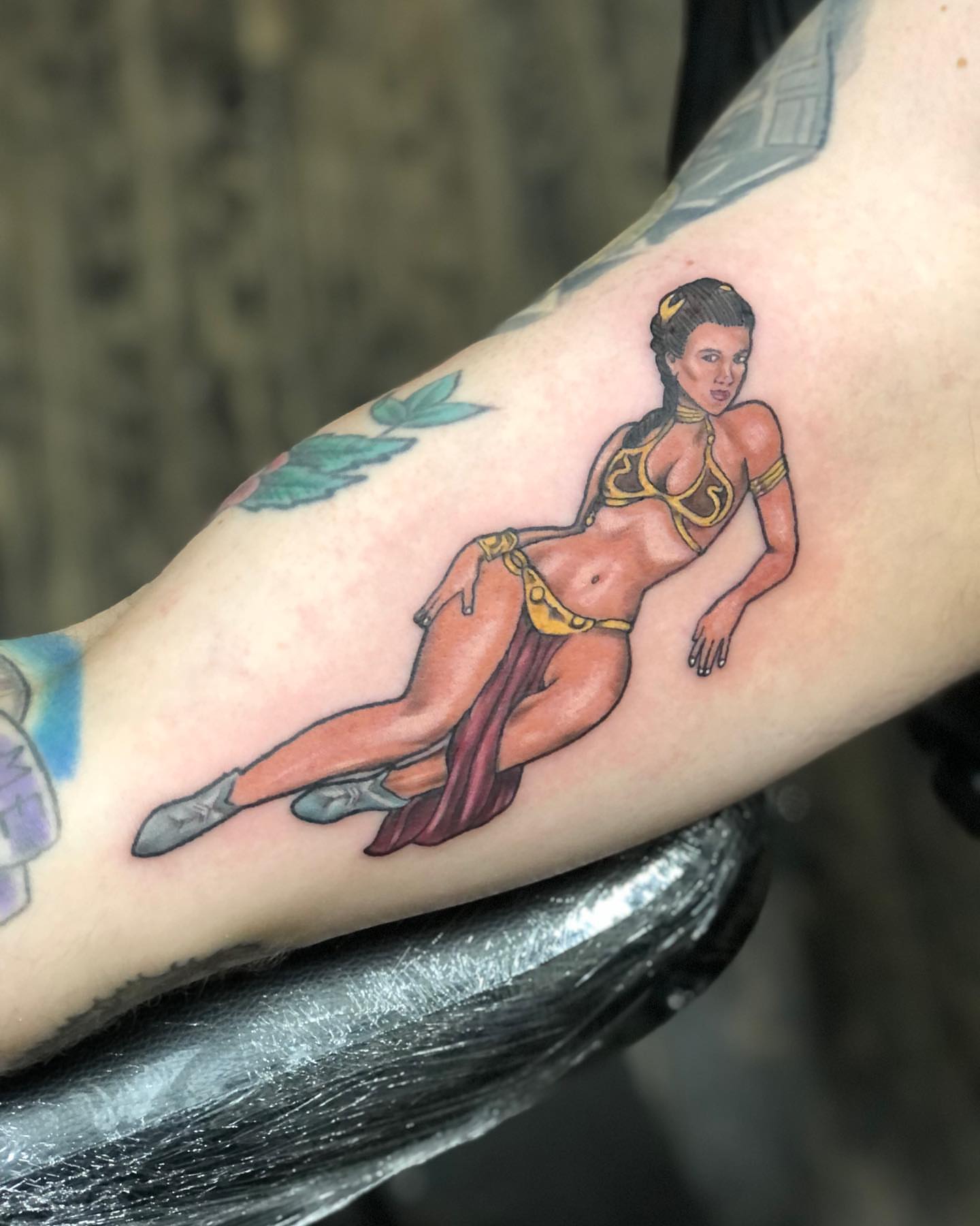 Woman in bikini realism tattoo on the forearm by A.W.