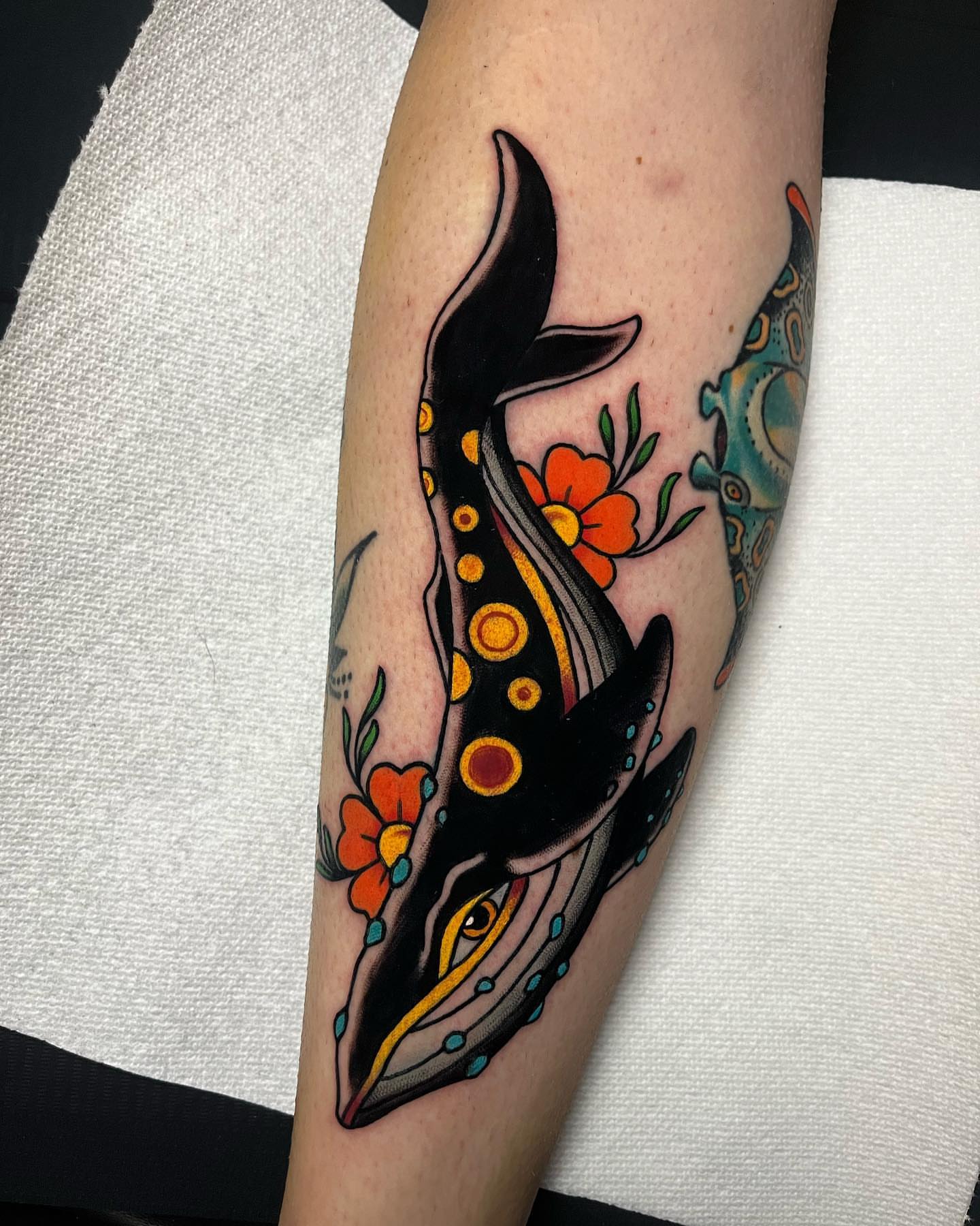 Whale and flowers American traditional tattoo on the forearm by Brian Diaz