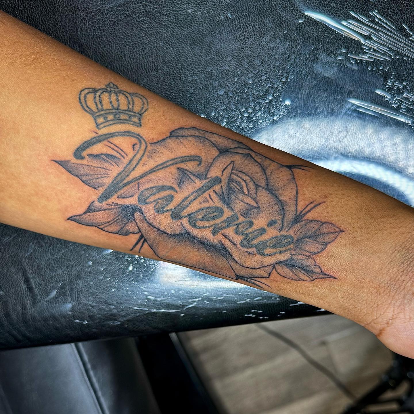 Rose with name black and grey tattoo on the forearm by Jess