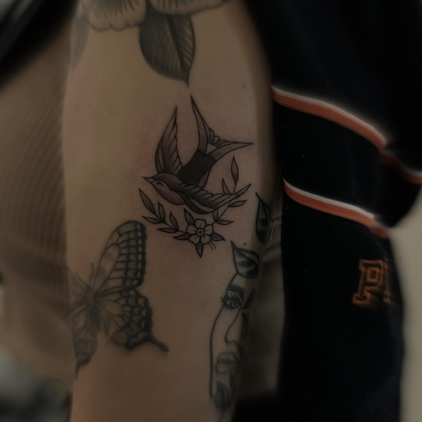 Bird and floral black and grey tattoo on the forearm by Jocelyn