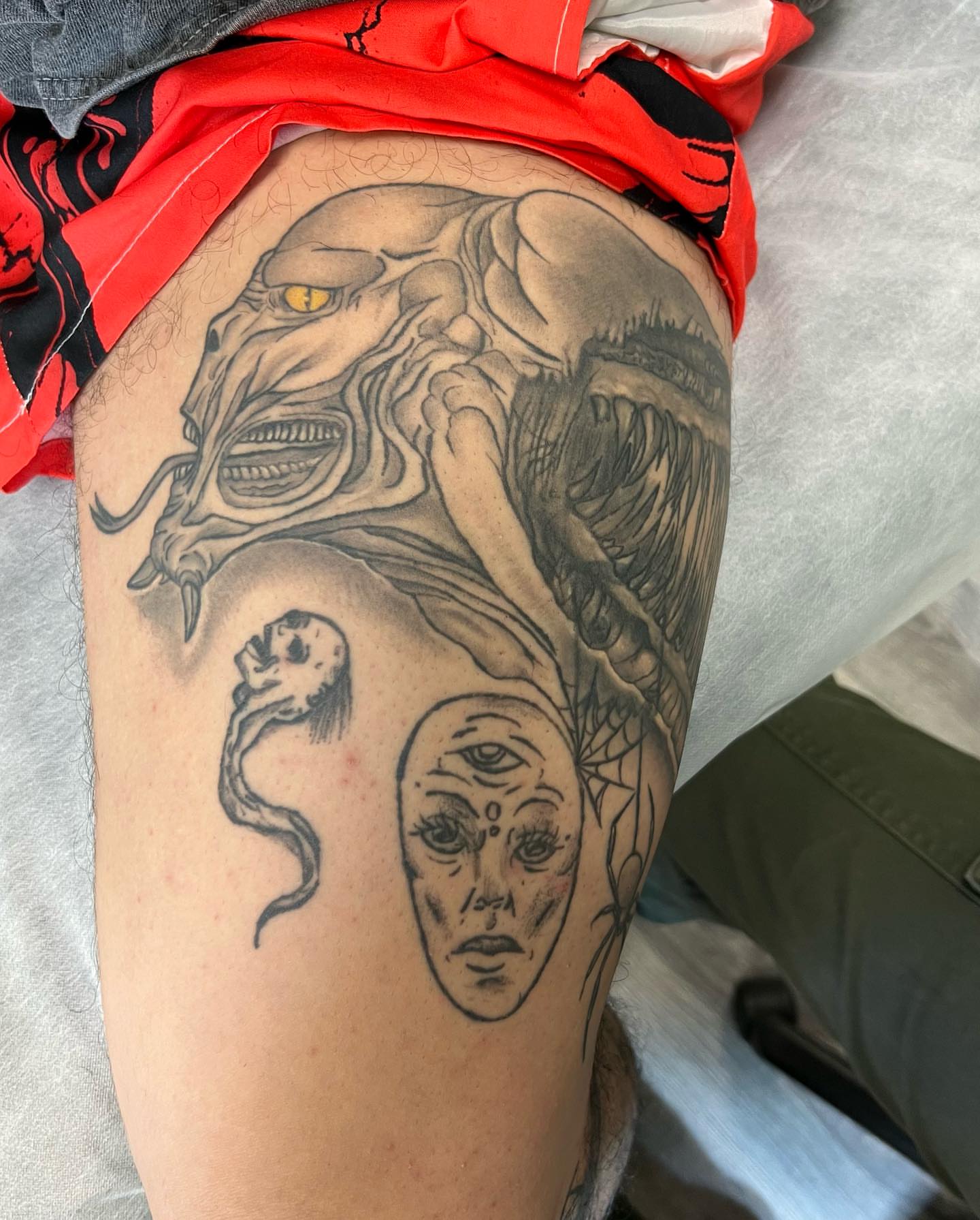 Monster and woman realism tattoo on the thigh by Tattoo Artist