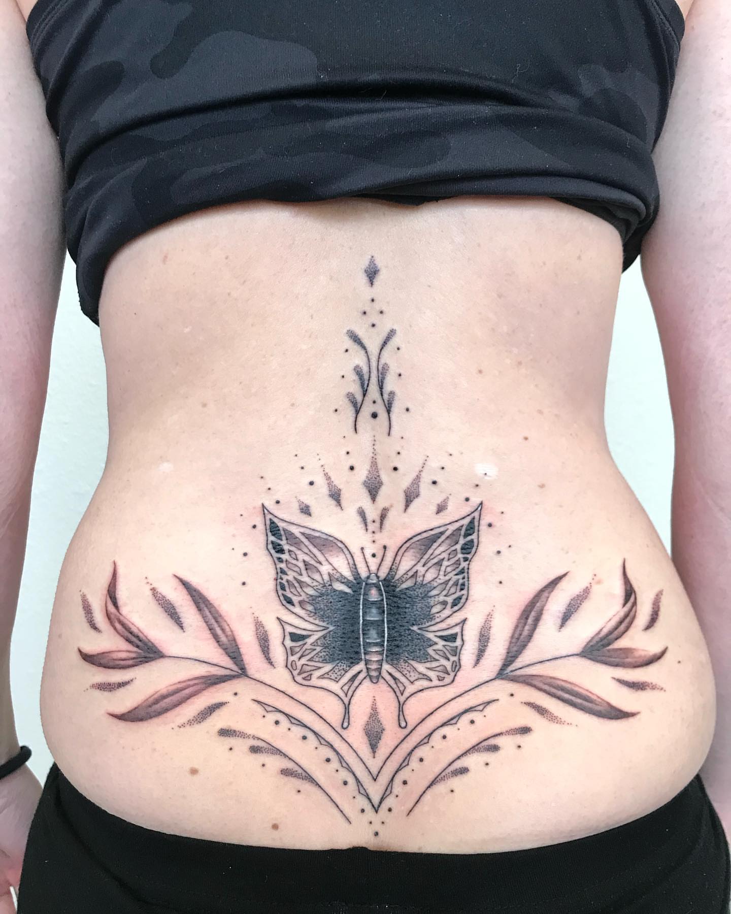 Butterfly dotwork tattoo on the torso by Ian Spencer