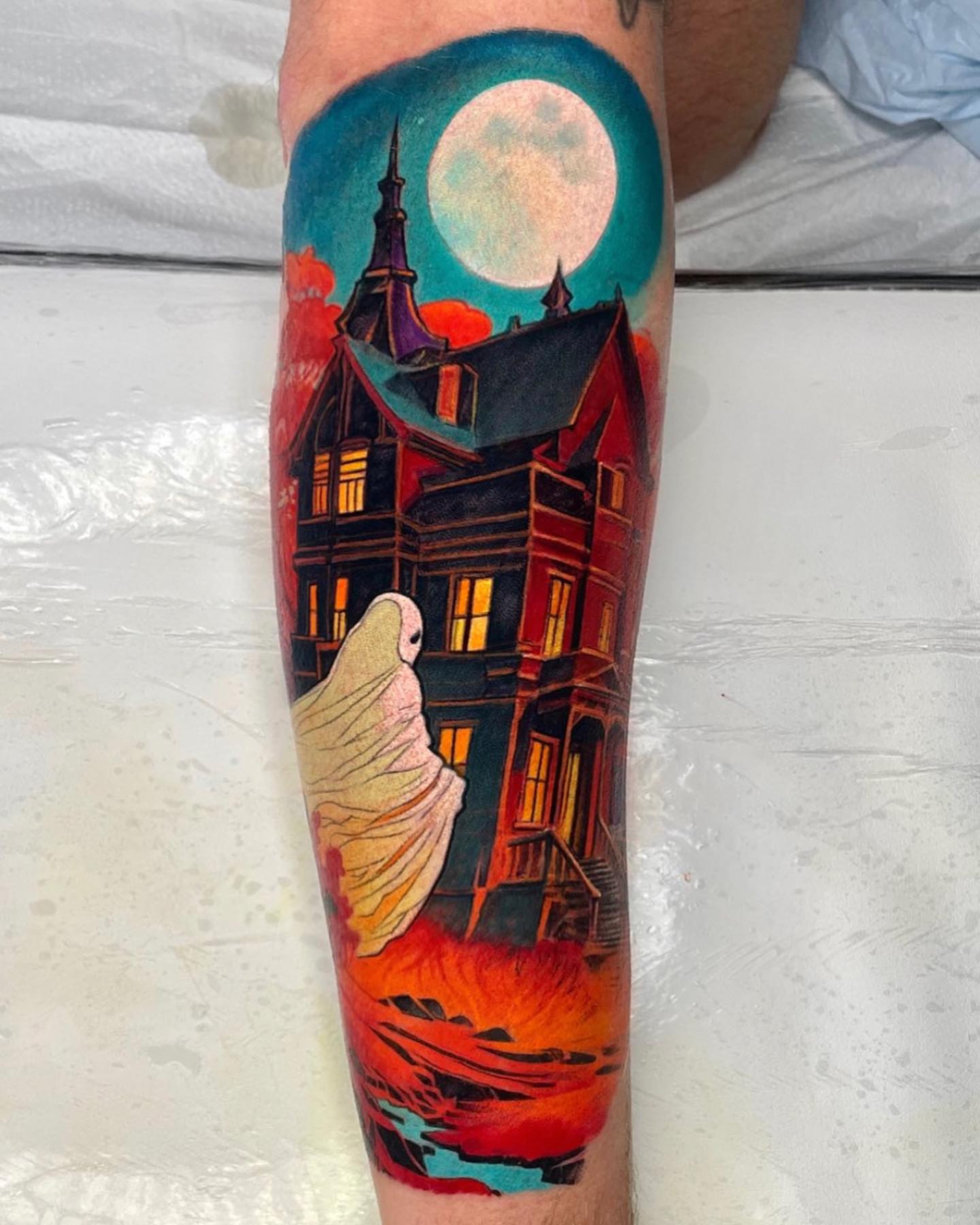 Haunted house ghost illustrative tattoo on the calf by Ericksen Linn