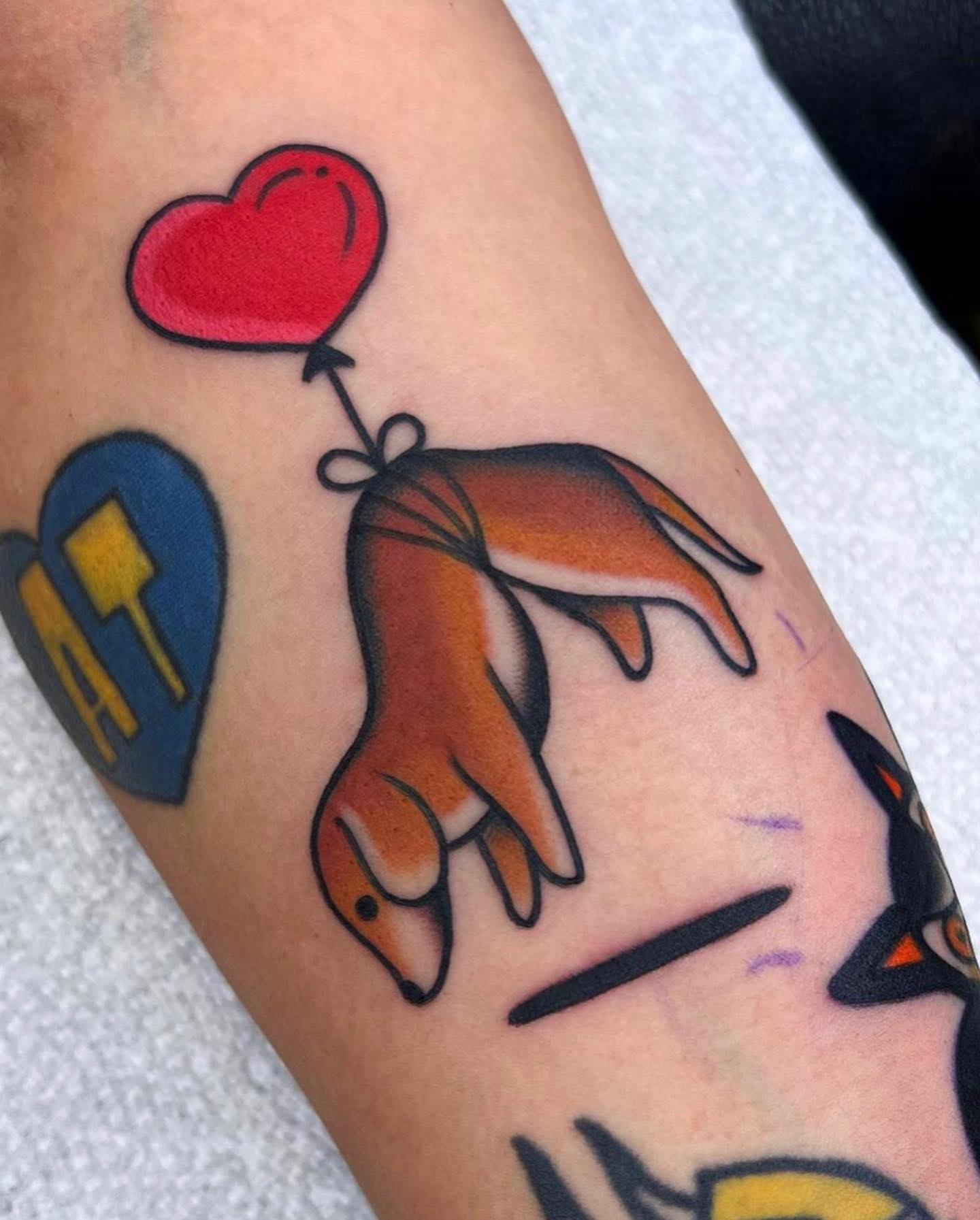 Fox with heart balloon American traditional tattoo on the forearm by Arturo Ledesma