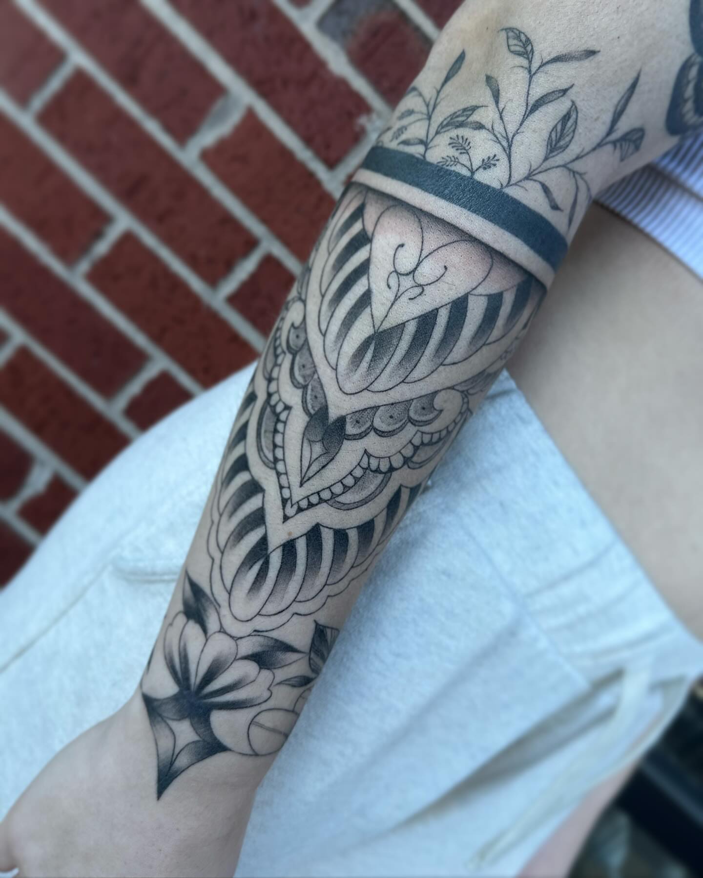 Floral and abstract black and grey tattoo on the forearm by Rachel Martinez