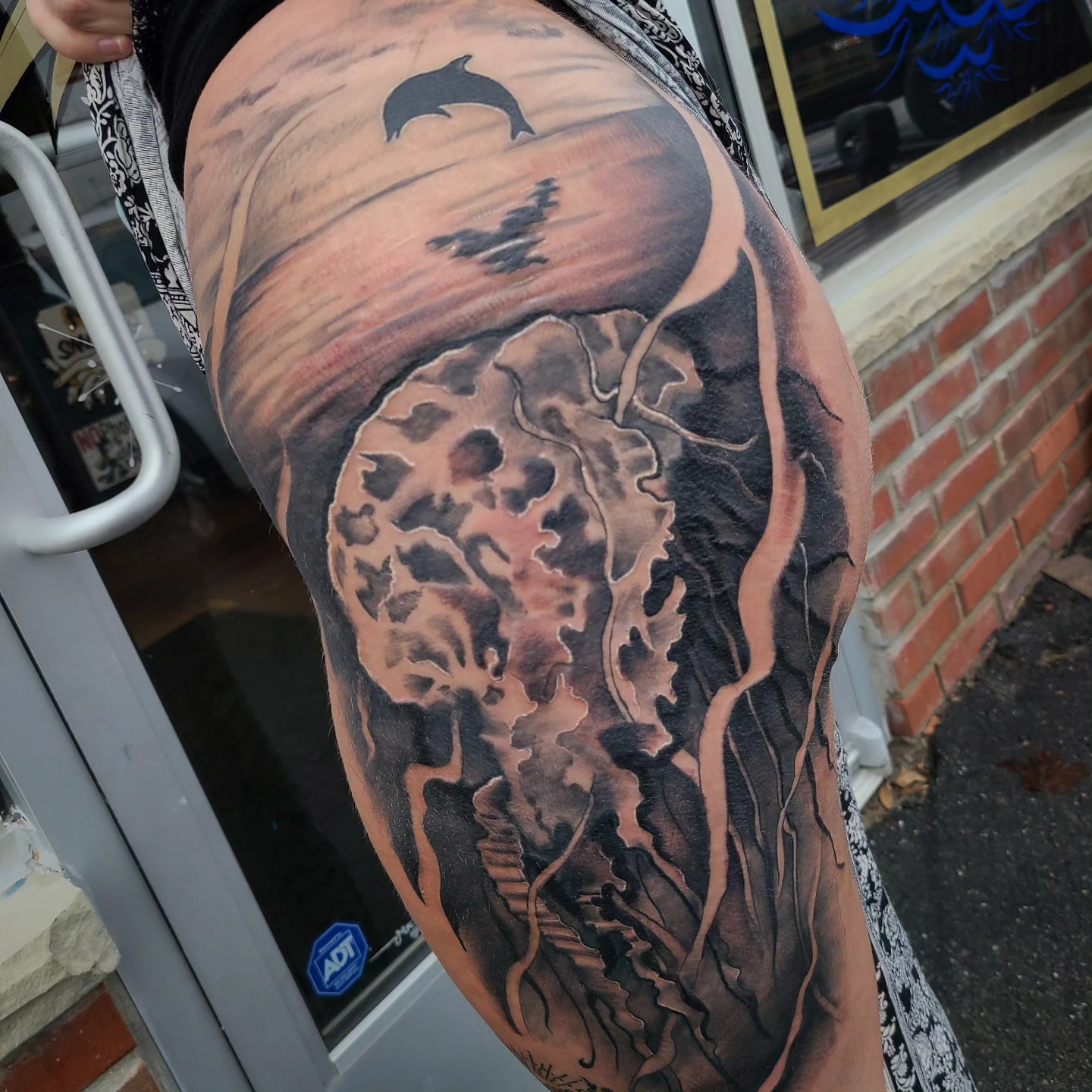 Wave and dolphin realism tattoo on the thigh by David Johnson