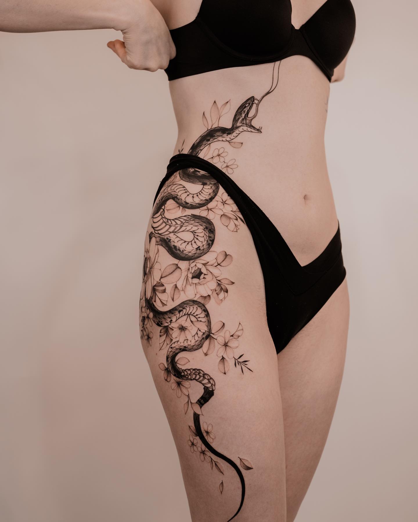 Snake and flowers realism tattoo on the thigh by Seattle Tattoo Artist PingPing, Seattle, Washington
