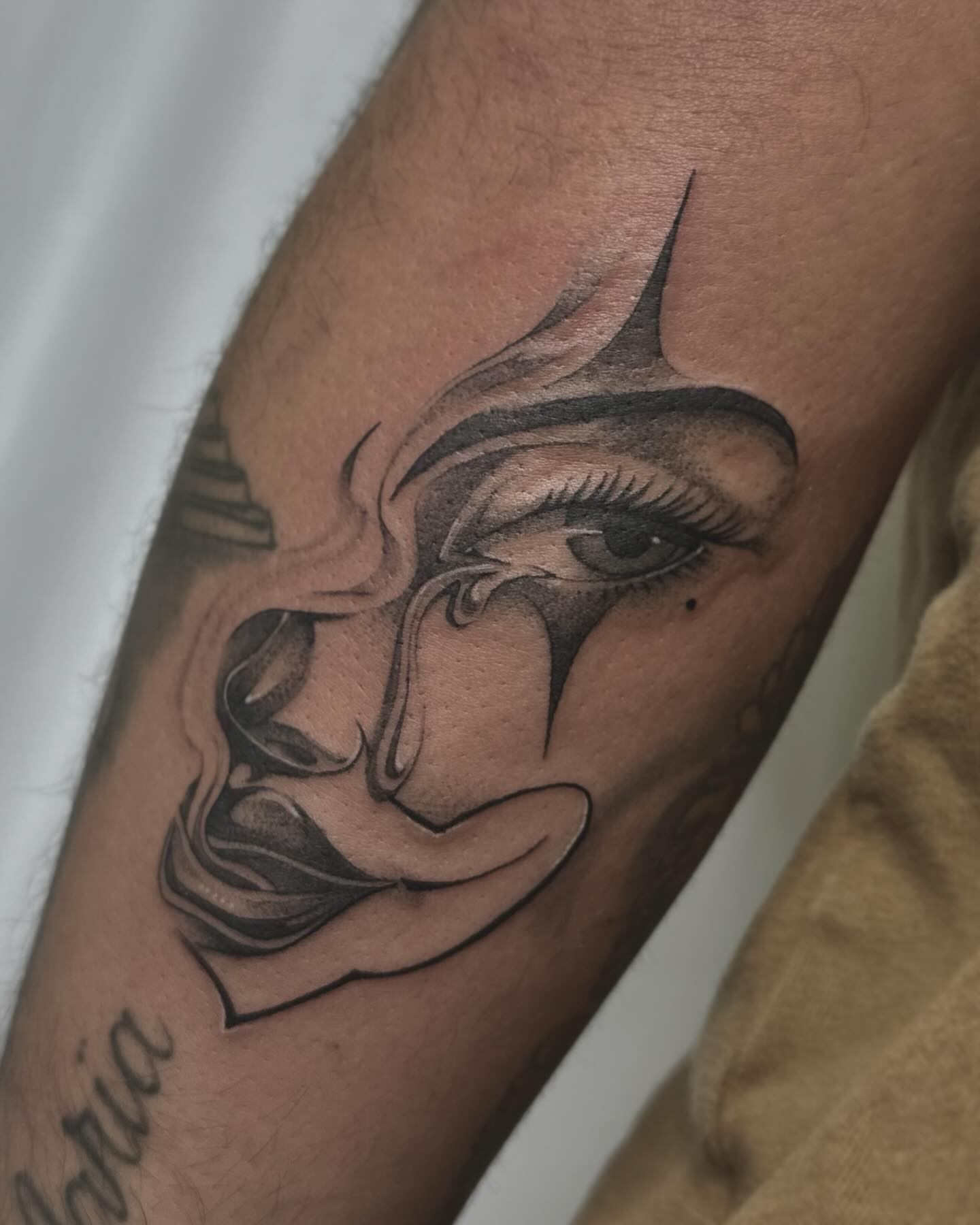 Abstract face realism tattoo on the forearm by Rachel Martinez