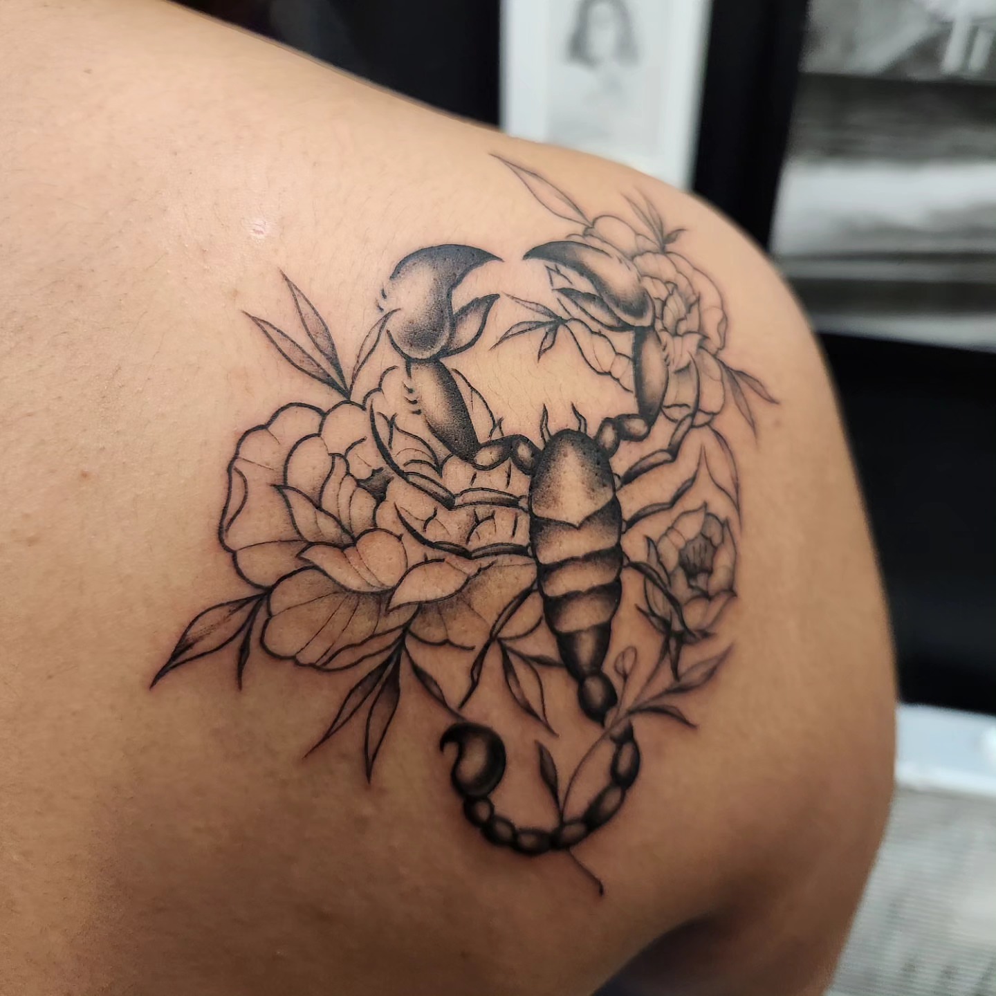 Scorpion and flowers black and grey tattoo on the shoulder by Adrian Chavez
