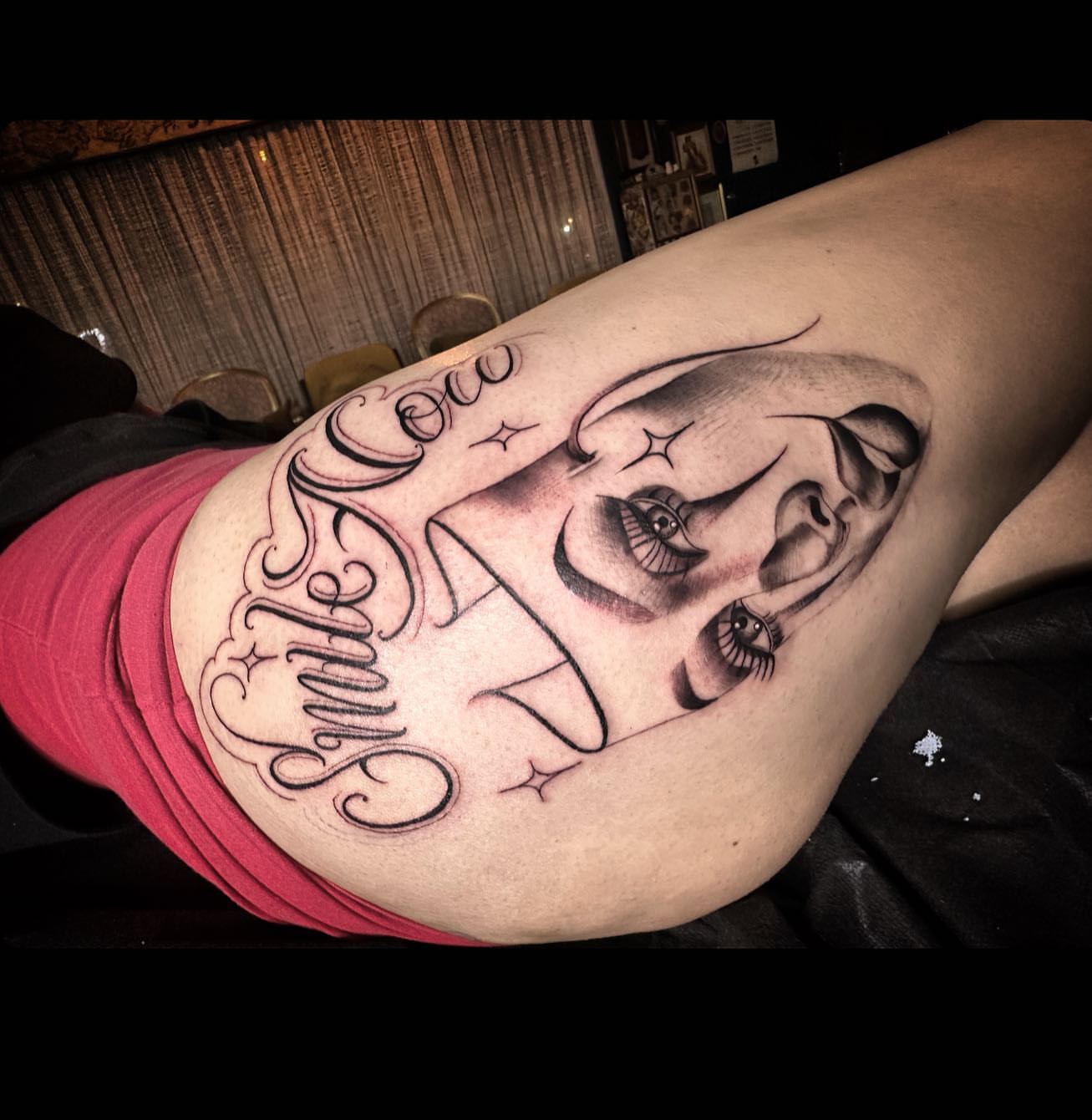 Smile black and grey tattoo on the thigh by Las Vegas Tattoo Artist