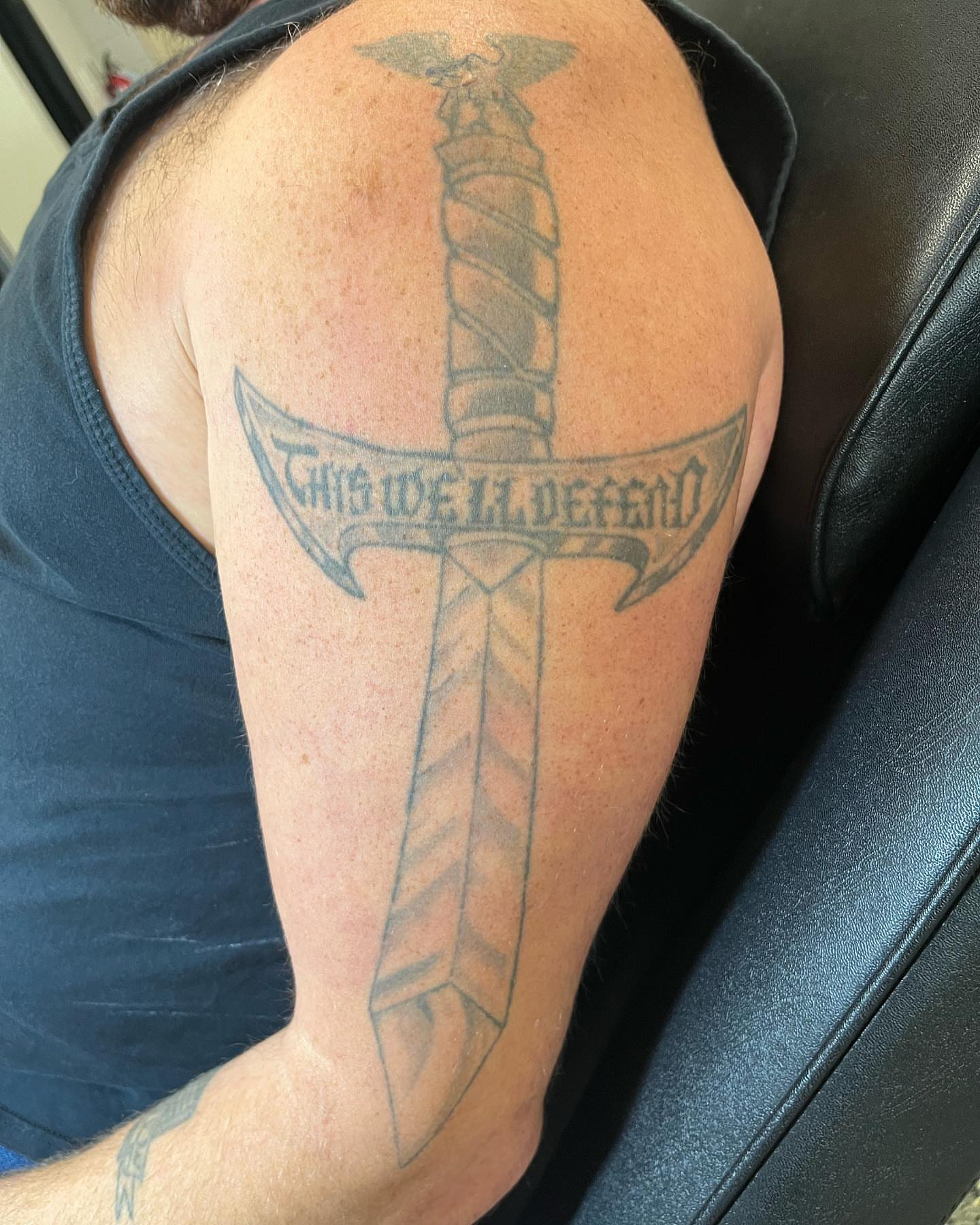 Sword and banner black and grey tattoo on the shoulder by oh hey, robin.