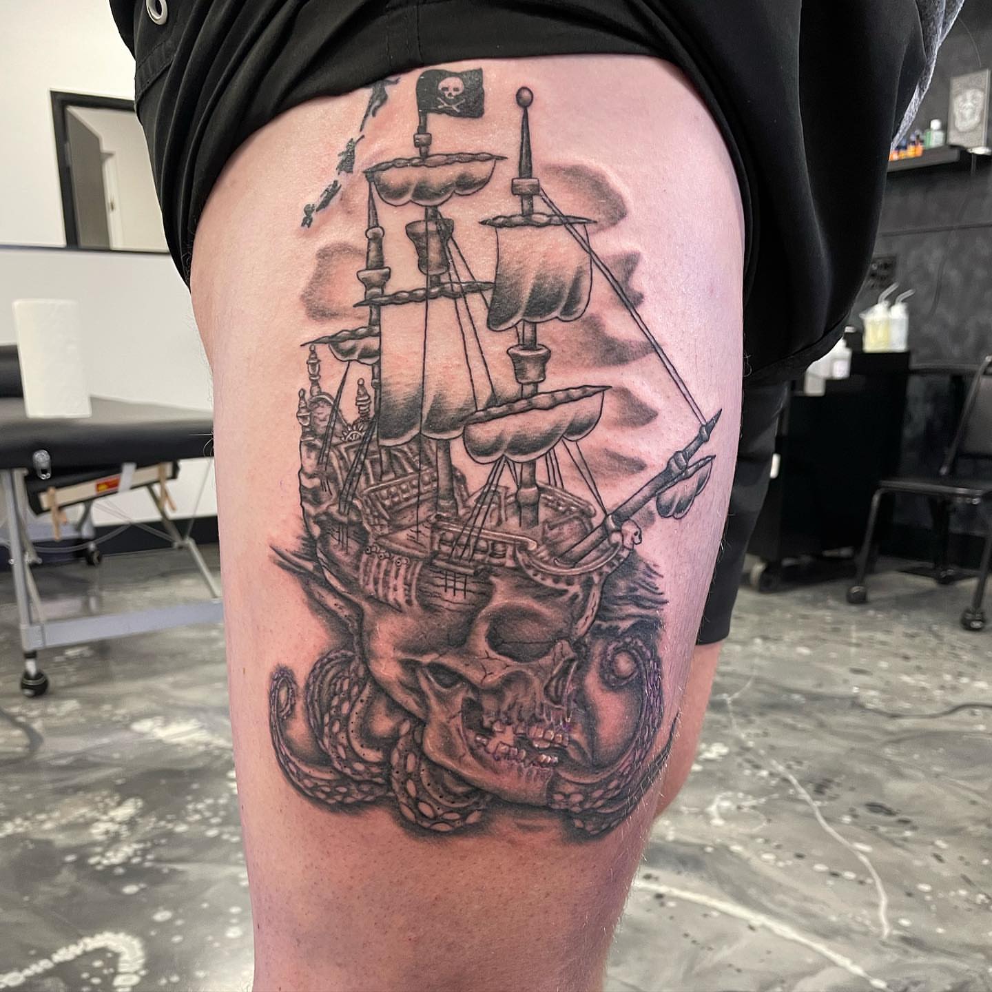 Pirate ship and skull realism tattoo on the thigh by Brandon Anderson