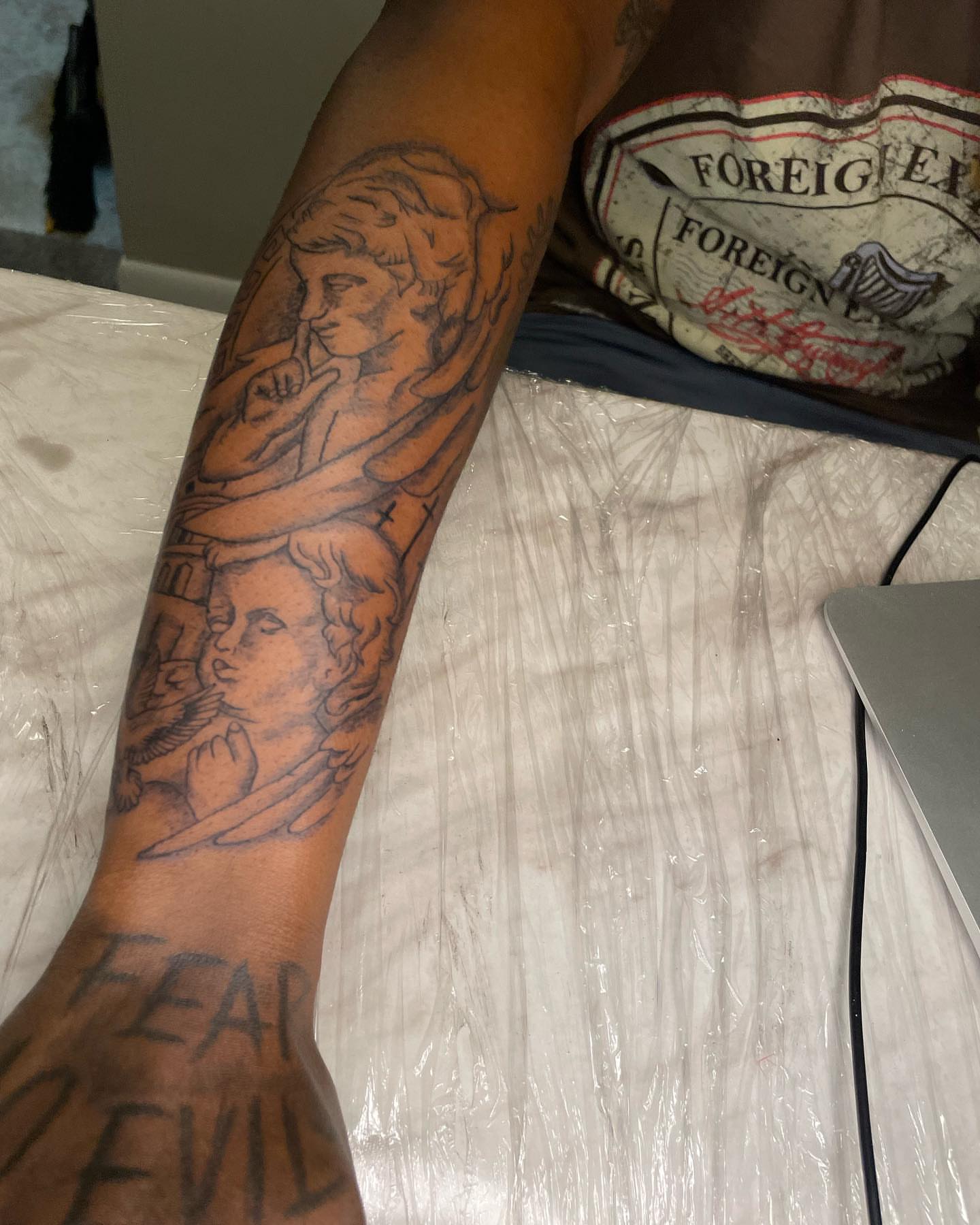 Angels black and grey tattoo on the forearm by Dinero Inks