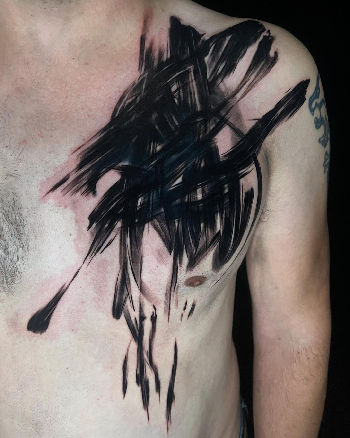 Abstract brush strokes black and grey tattoo on the chest by Ben Viamontes