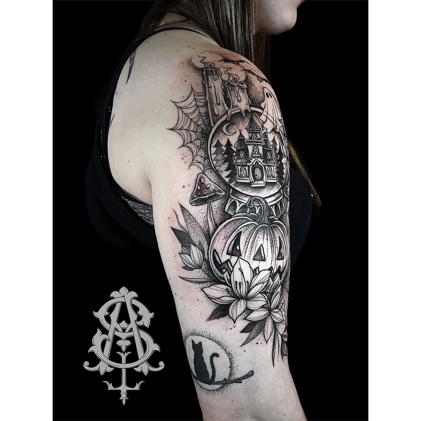 Haunted house and pumpkin dotwork tattoo on the upper arm by Amber Jane Strange
